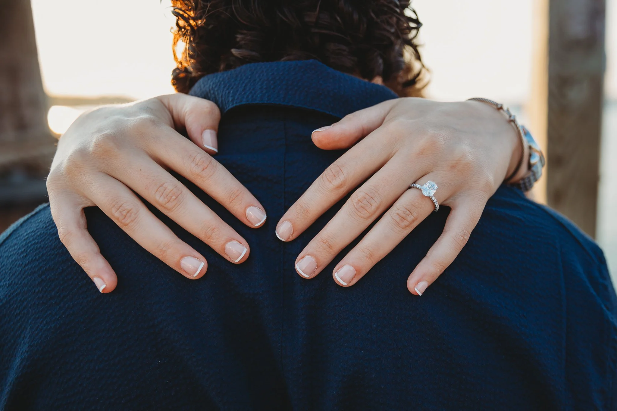 close up of woman's hands on man's shoulders after getting engaged