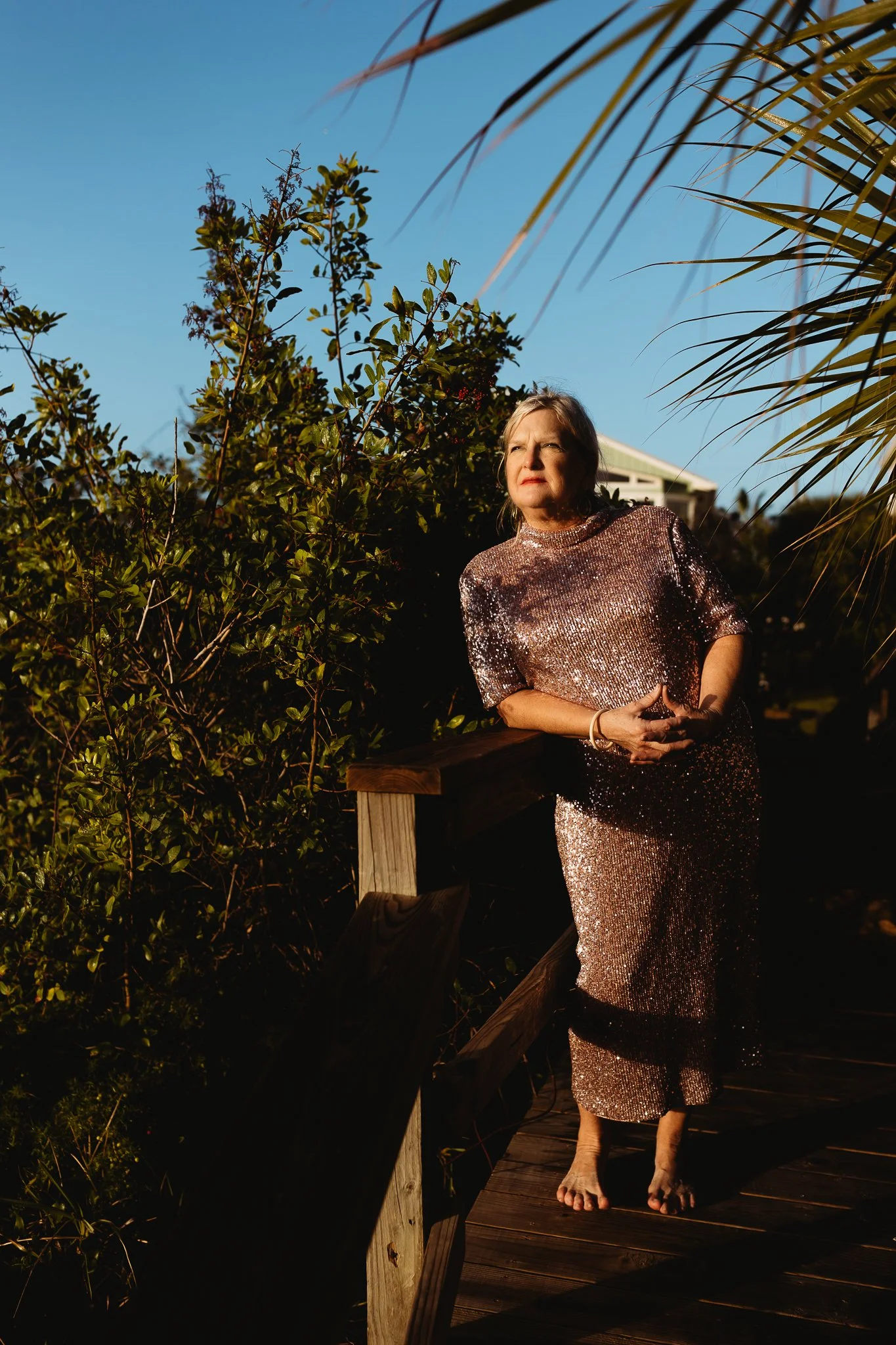 Woman celebrating her 70th birthday during a sunrise portrait session on a beach walkway in Crescent Beach, Florida.