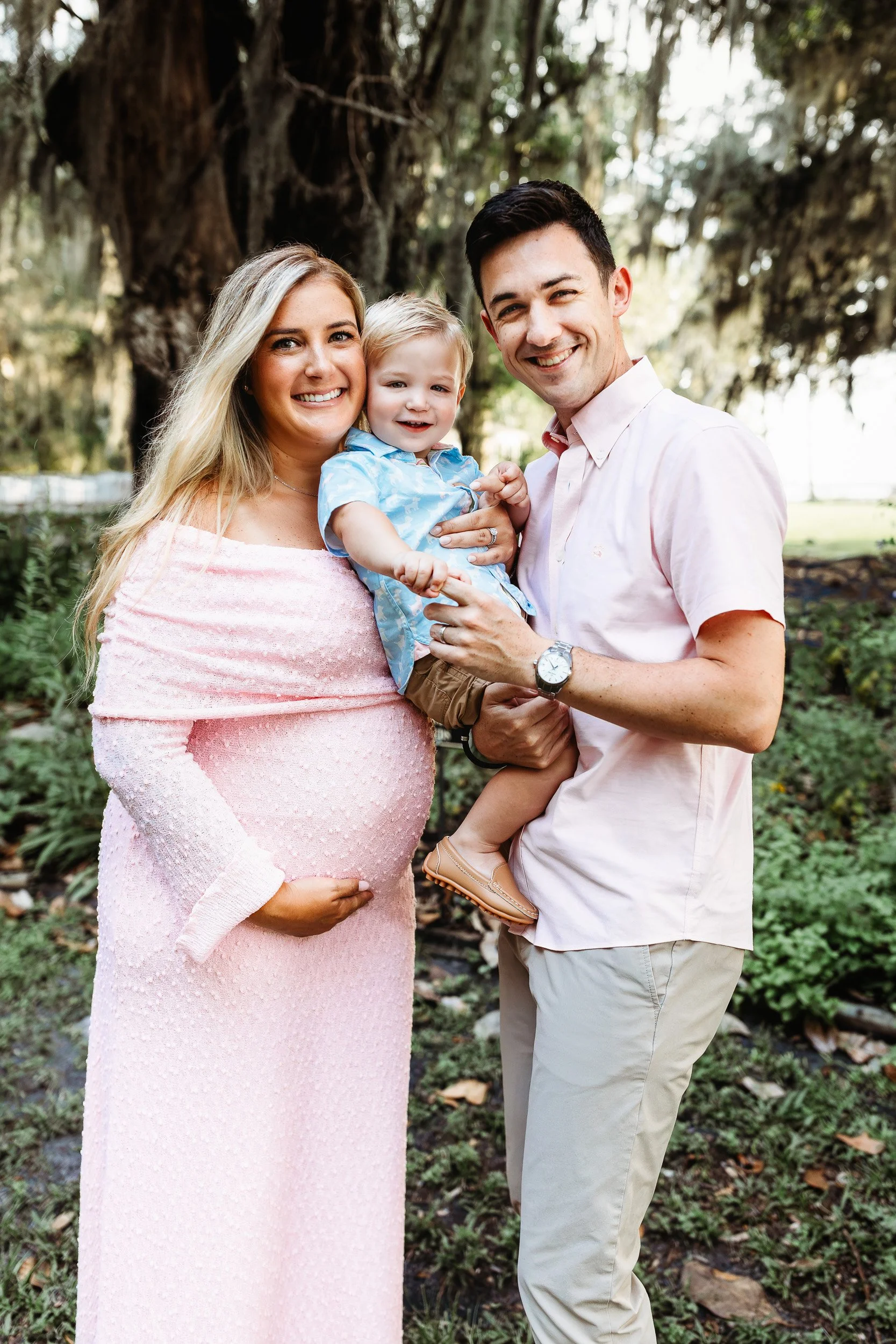 Parents and toddler celebrating the arrival of a new baby during a maternity photo session.