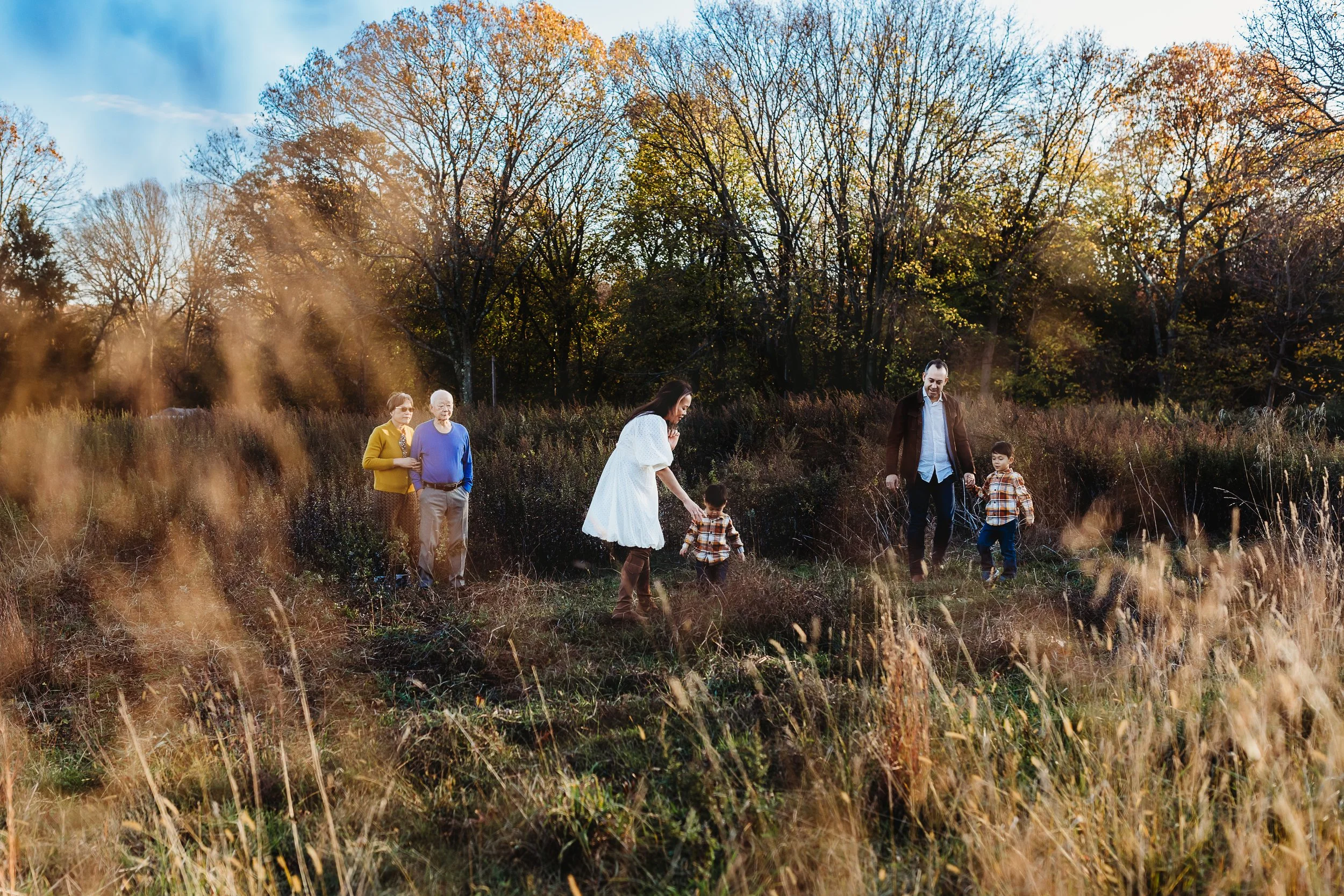 family walking through a field with toddlers in the fall