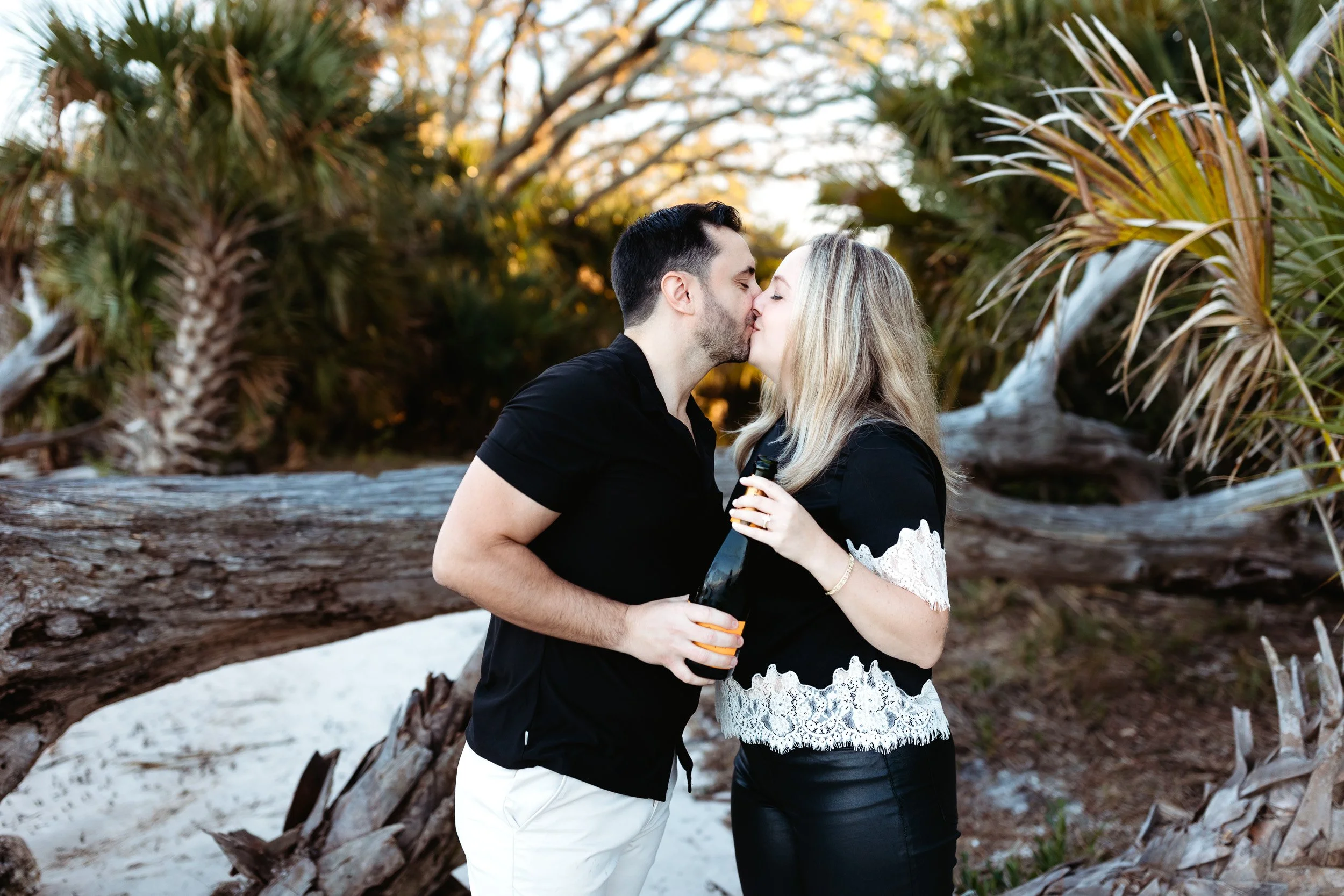 Recently engaged couple walking on the beach at sunset in St. Augustine after their proposal