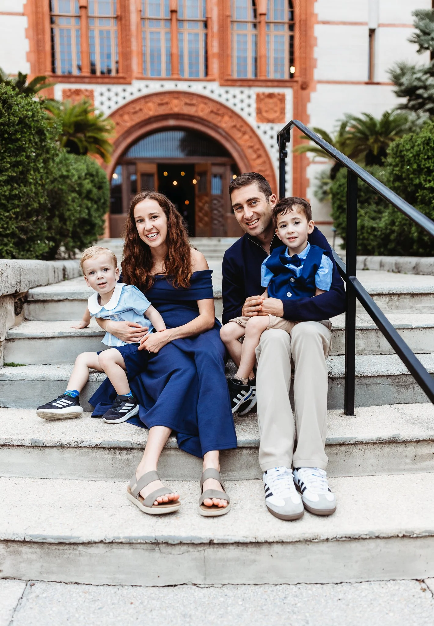 family in navy at Flagler during photo session lifting kids in air and laughing