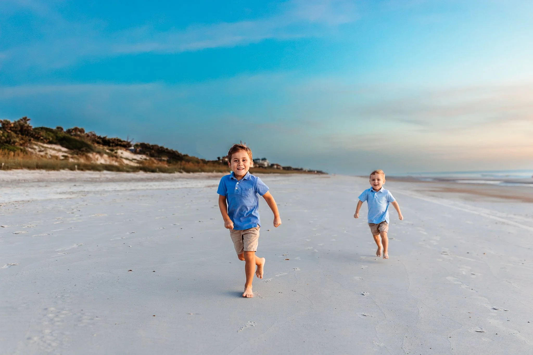 boys running on the beach at blue hour and laughing