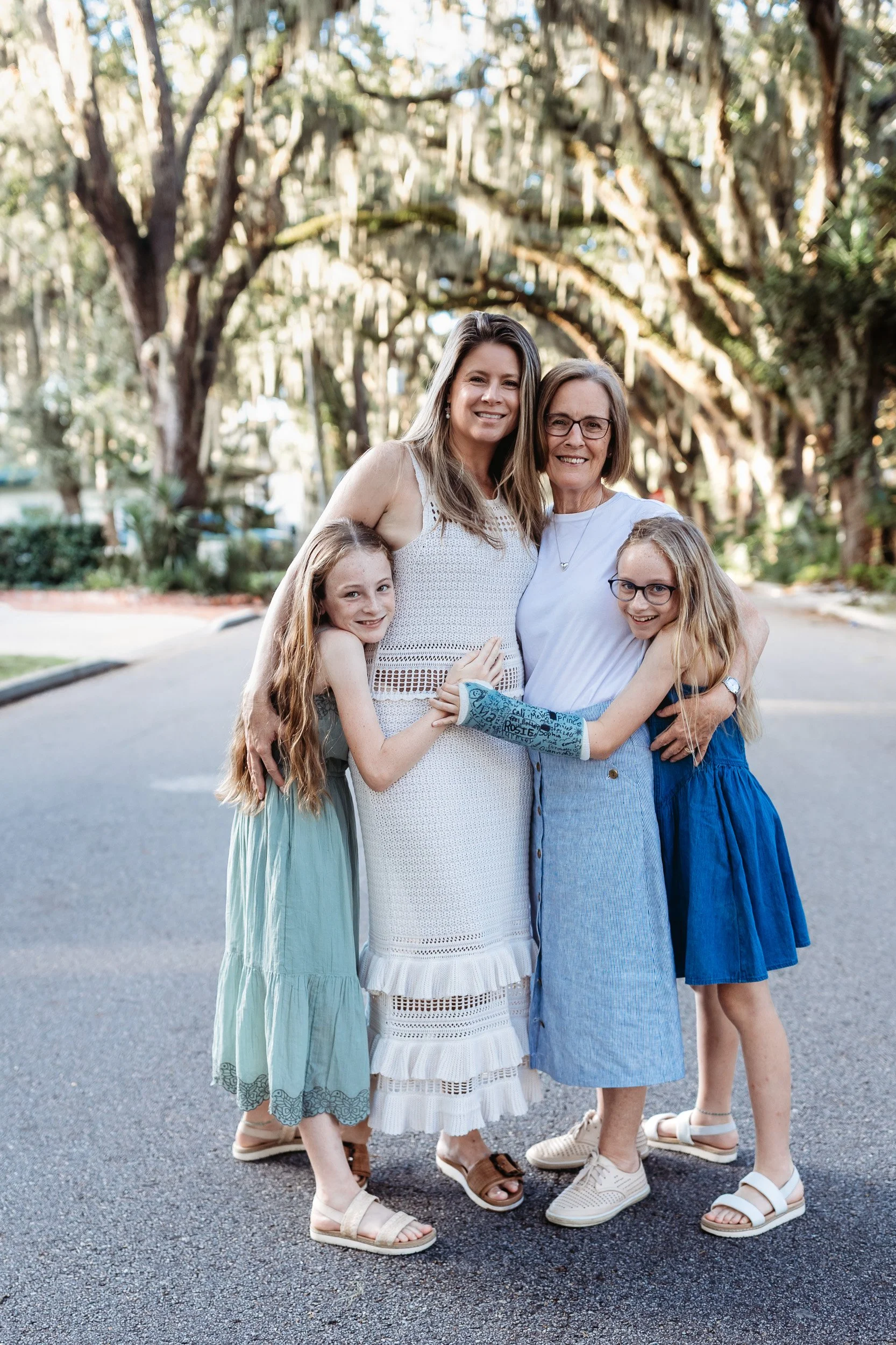 mother in a cream crochet dress with twin girls on a historic street in st augustine for family photos