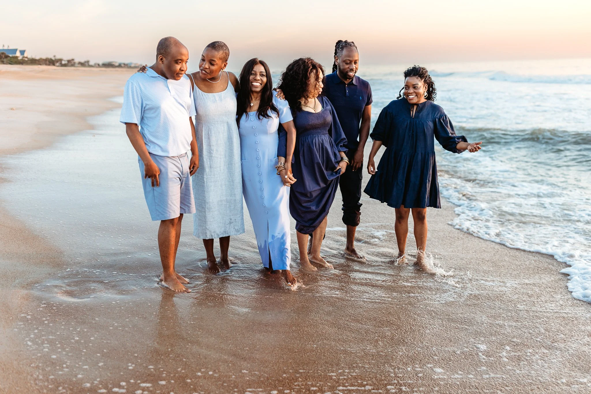 family enjoying the final moments of a sunrise beach session with soft golden morning light
