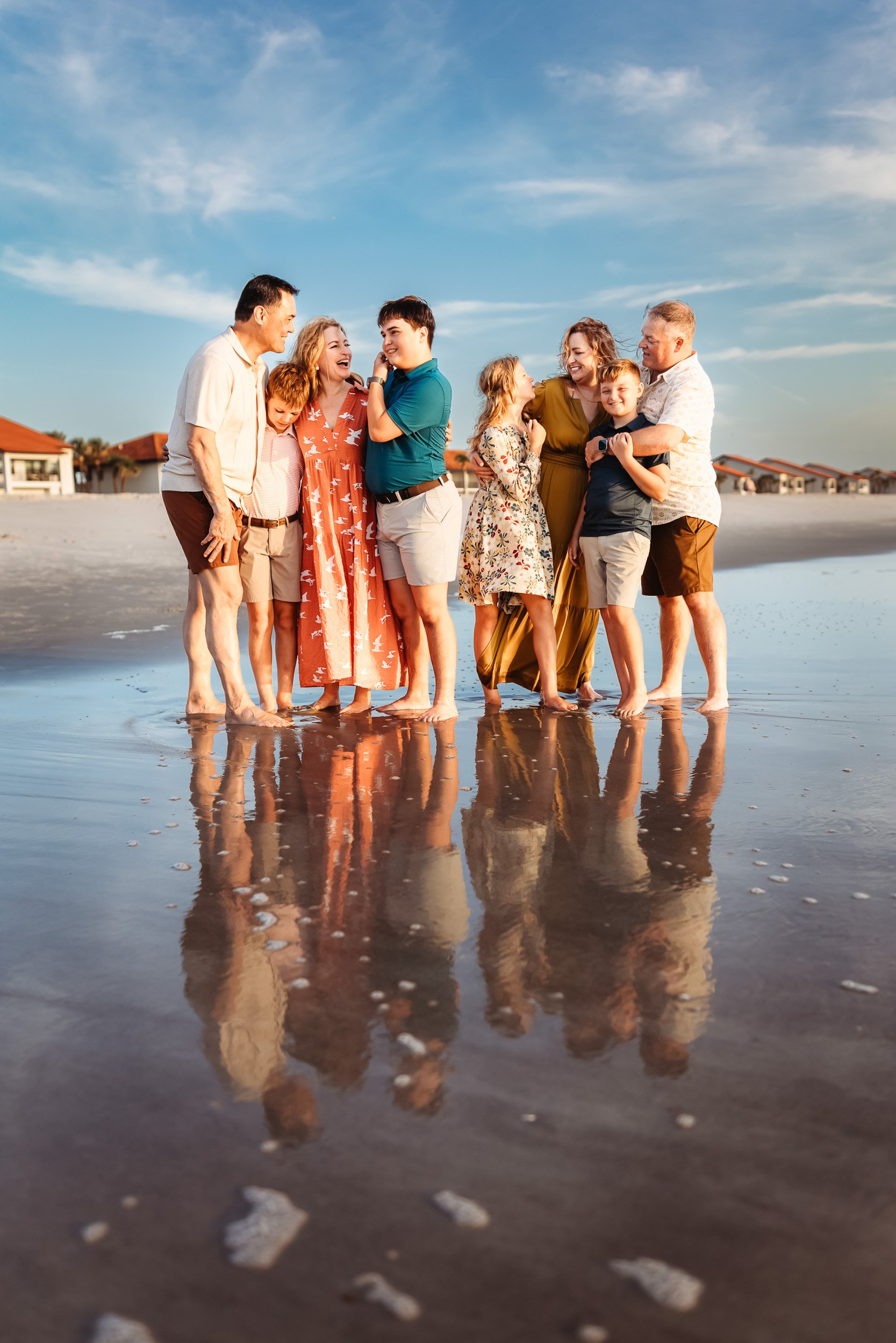 artistic image of a family embraced not he each at sunset with their reflection in the sand