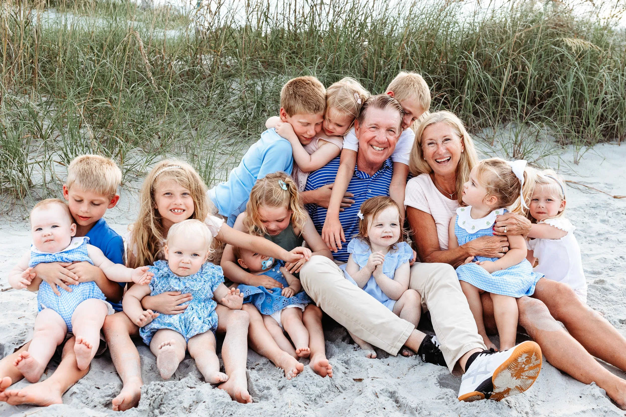 grandparents with all of their grandbabies piled on them at the beach for sunset family photos