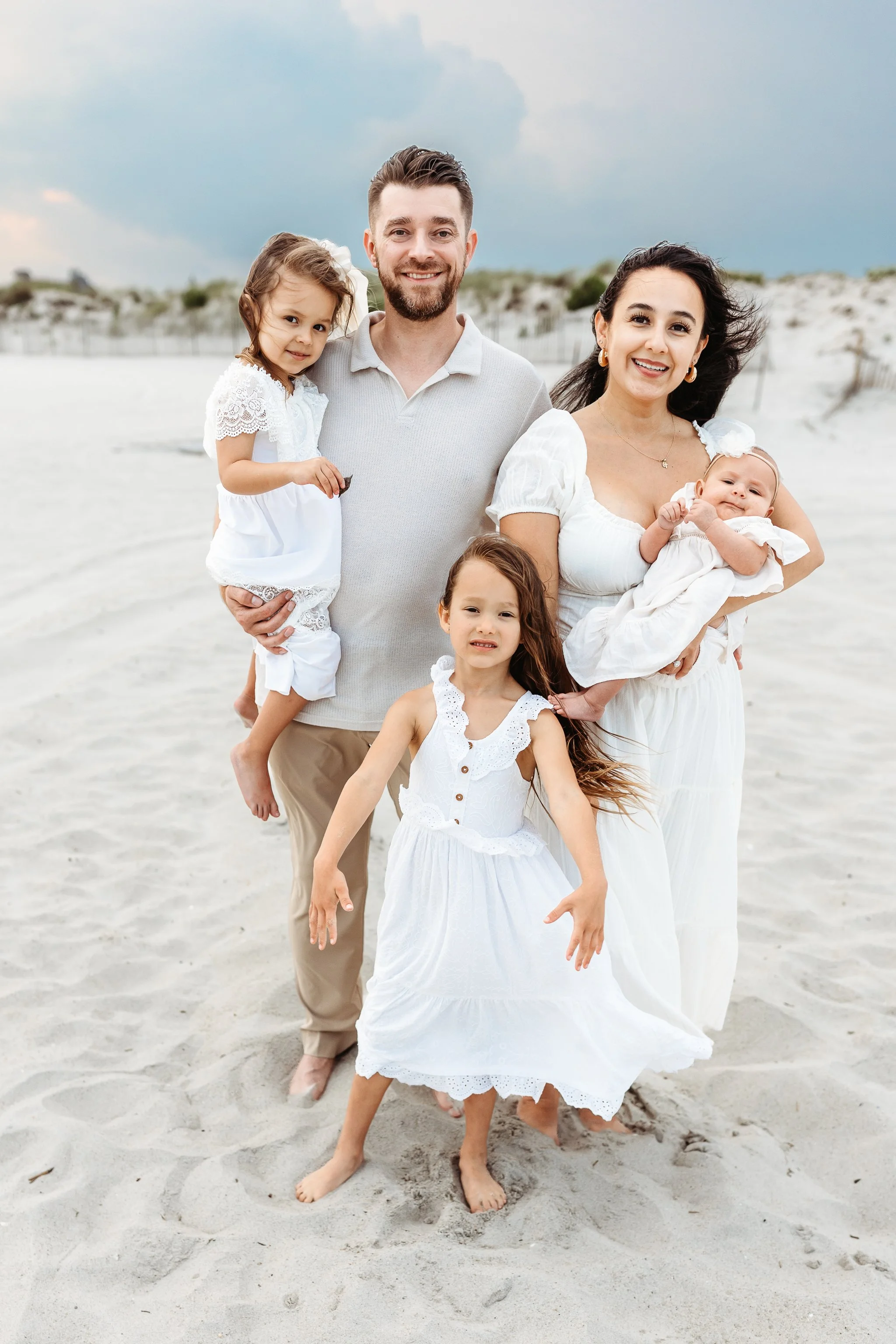 traditional family portrait on the beach with a new baby