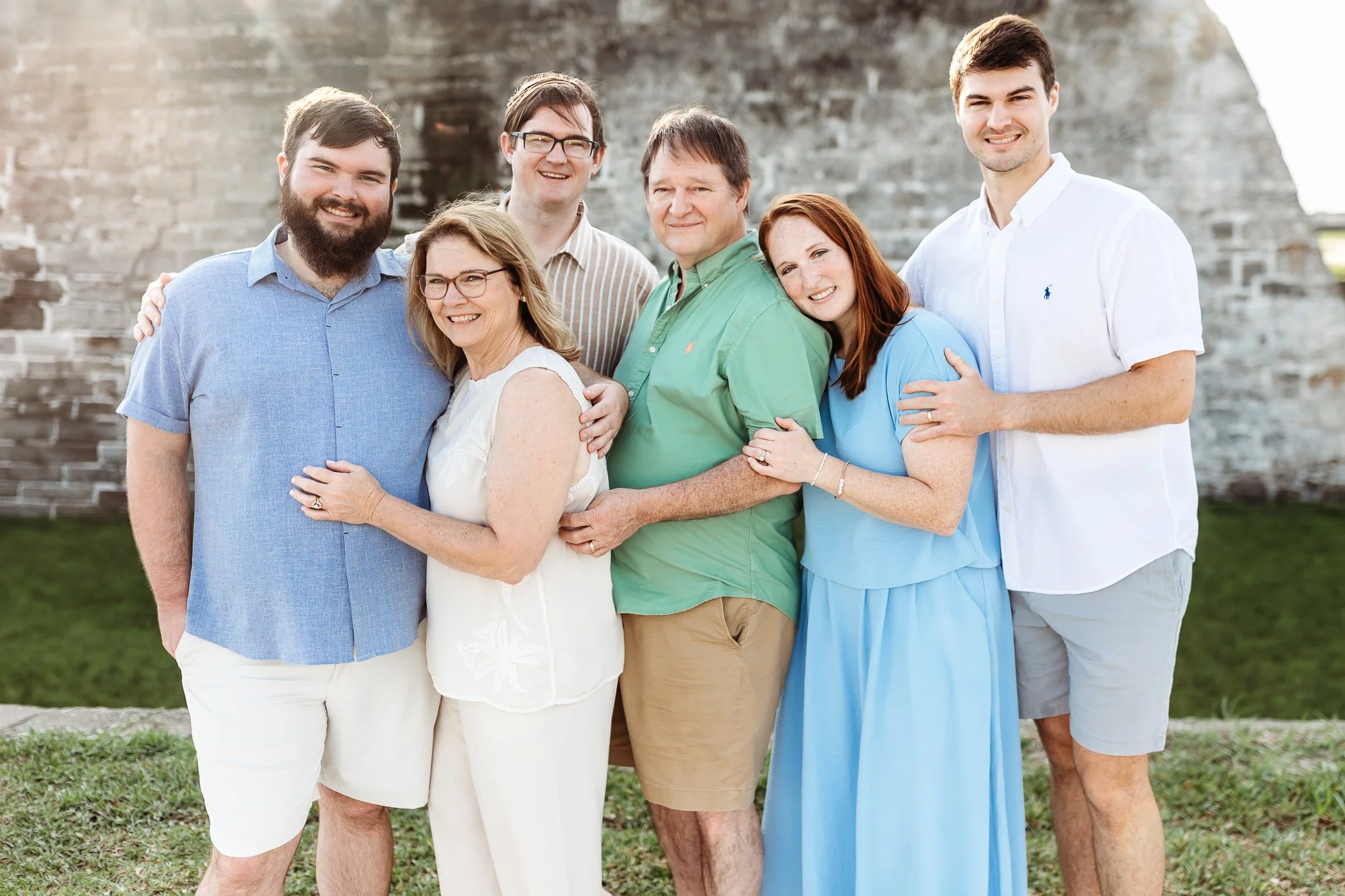 parents with adult children in front of the fort with pretty bright light shining