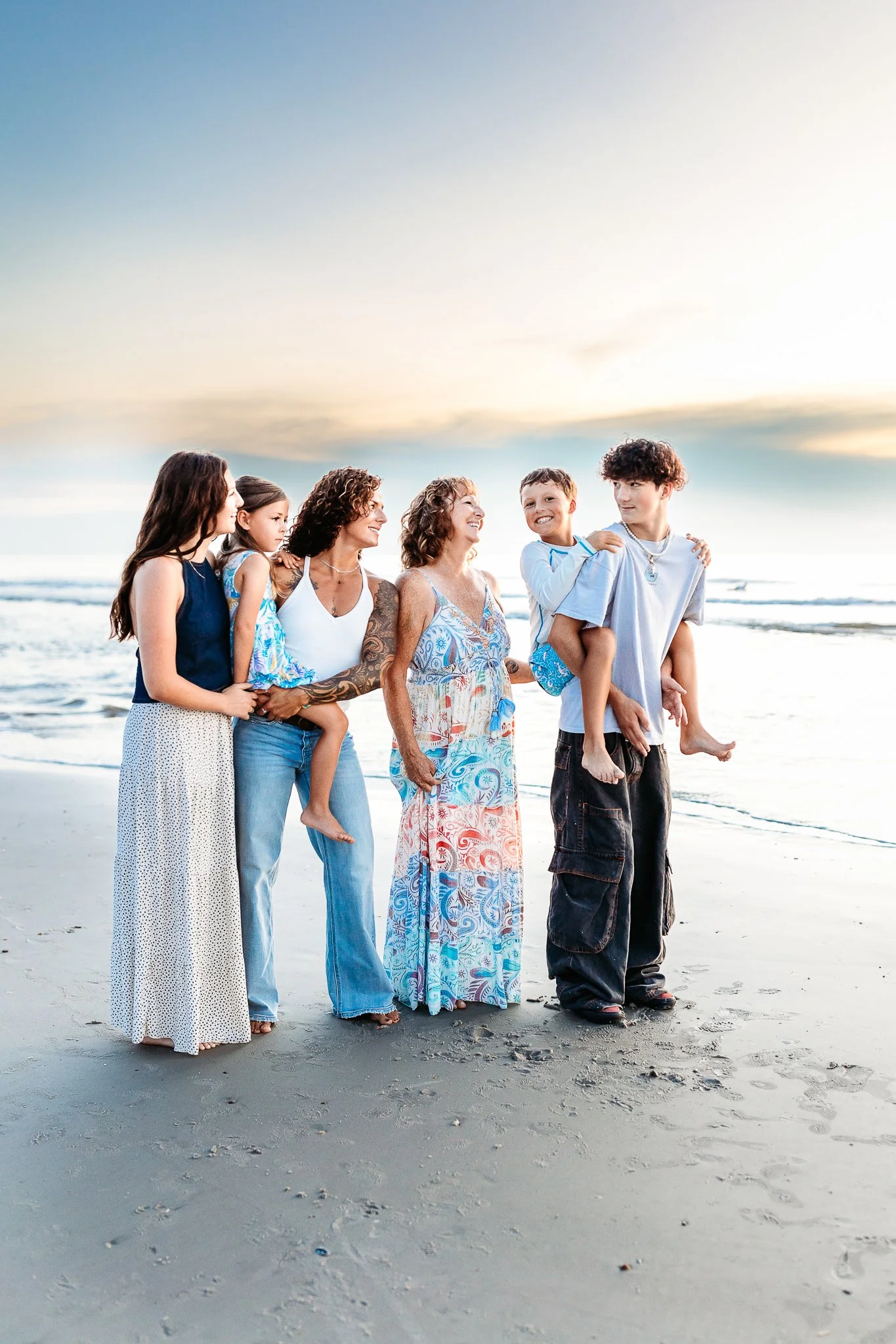 family on the beach at sunrise for photos while they are on vacation