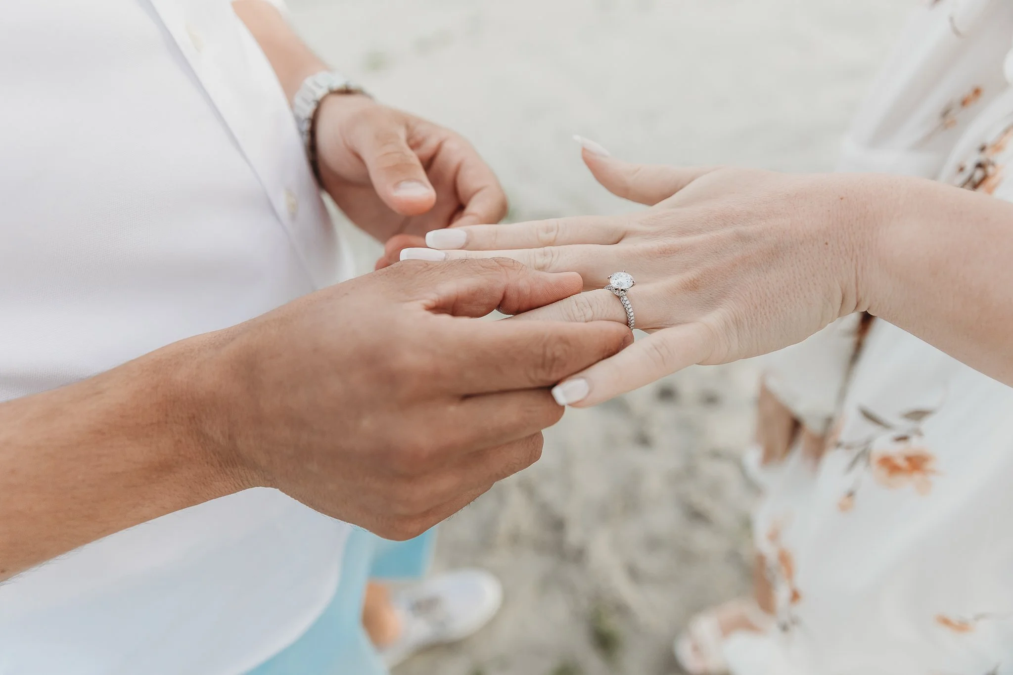man sliding a rung on a woman's finger while proposing
