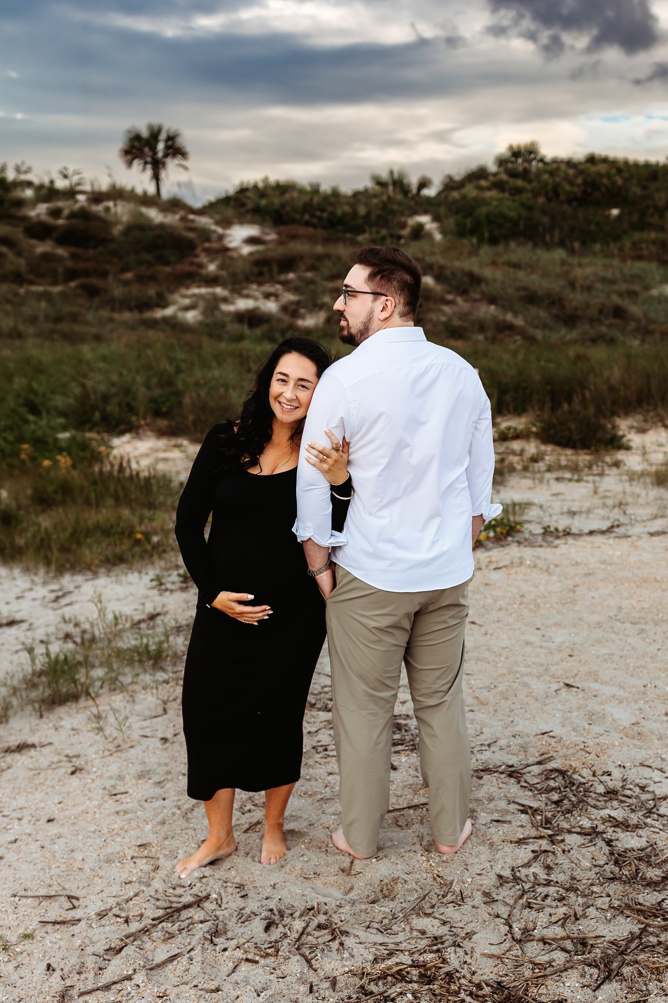 expecting couple holding each other during maternity portraits at Guana North.