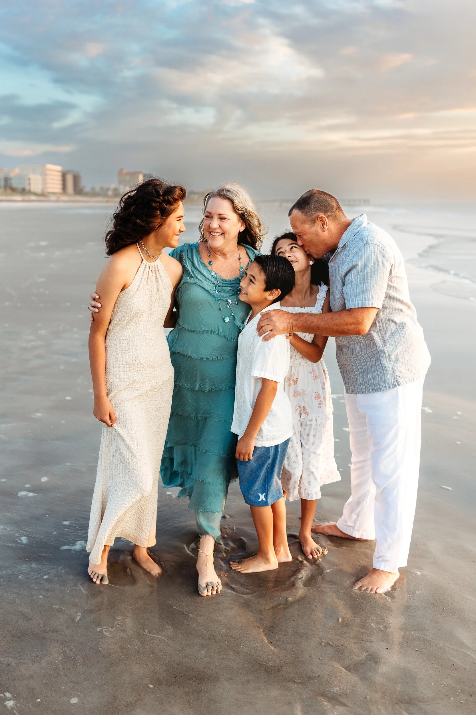 grandparents embracing their grandchildren while on vacation in Jax beach for a family photo session