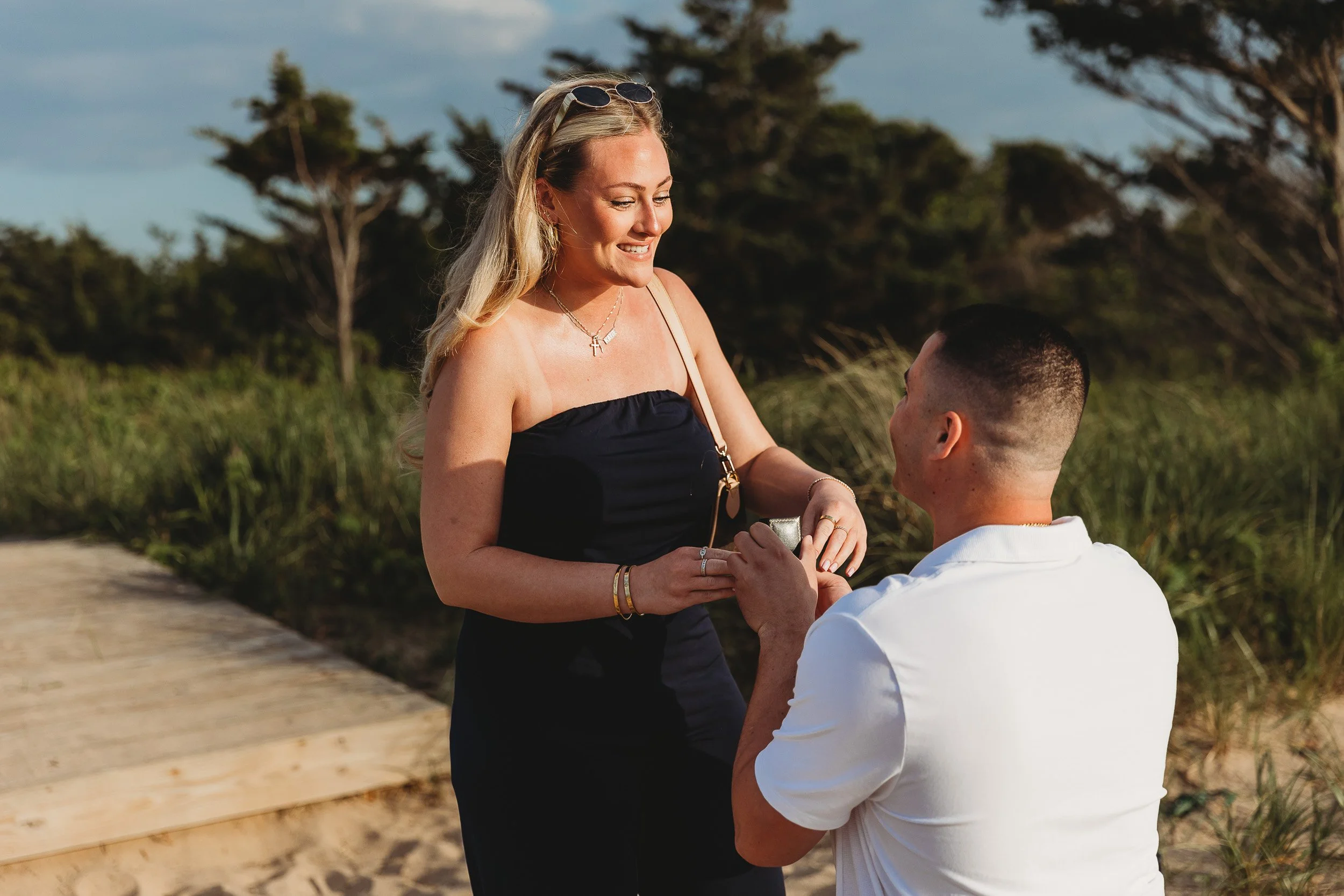 close up of woman with a man on knee and ring box in his hand in front of him 