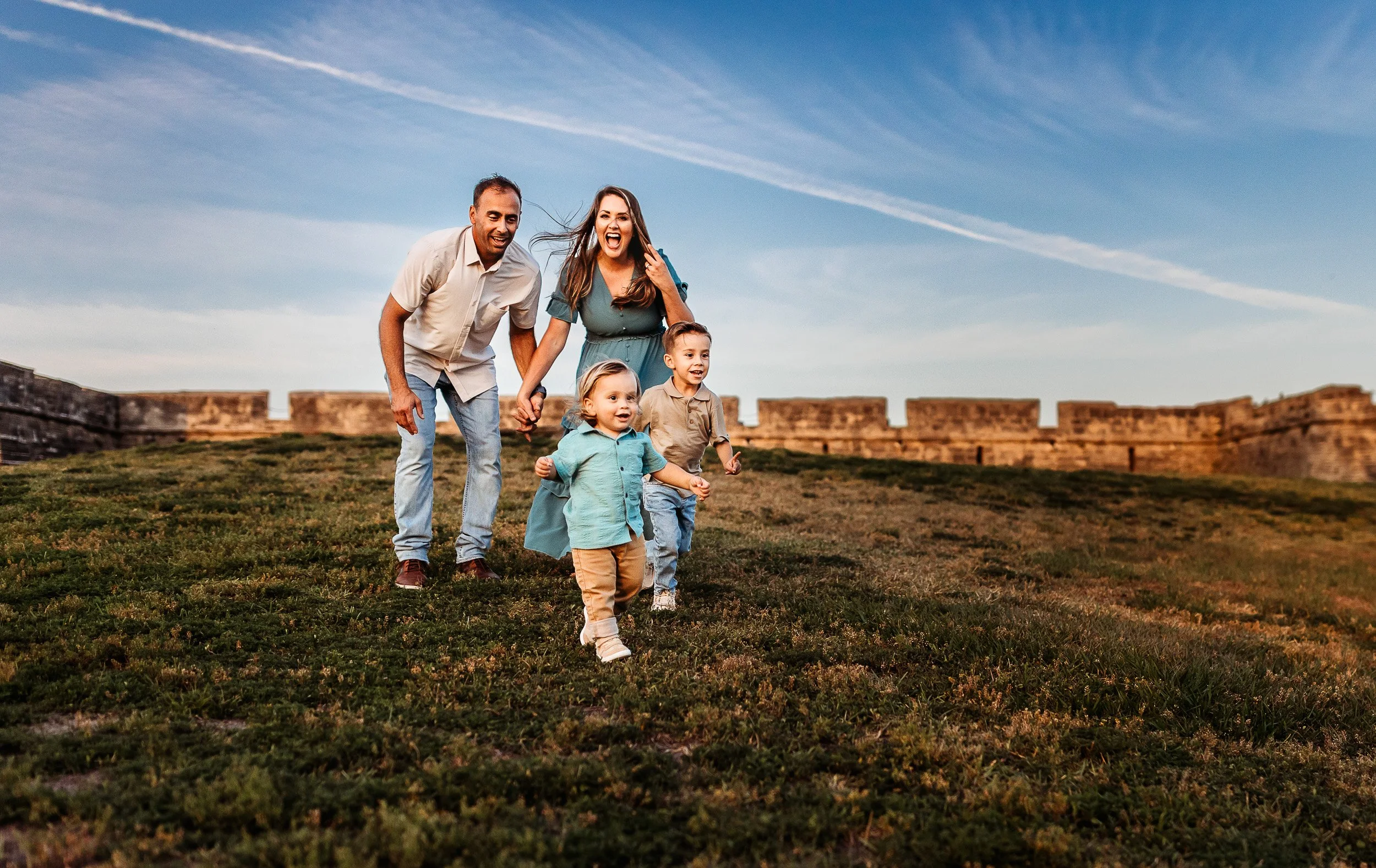 family running down the hill at the fort in st augustine during a sunset family photo session