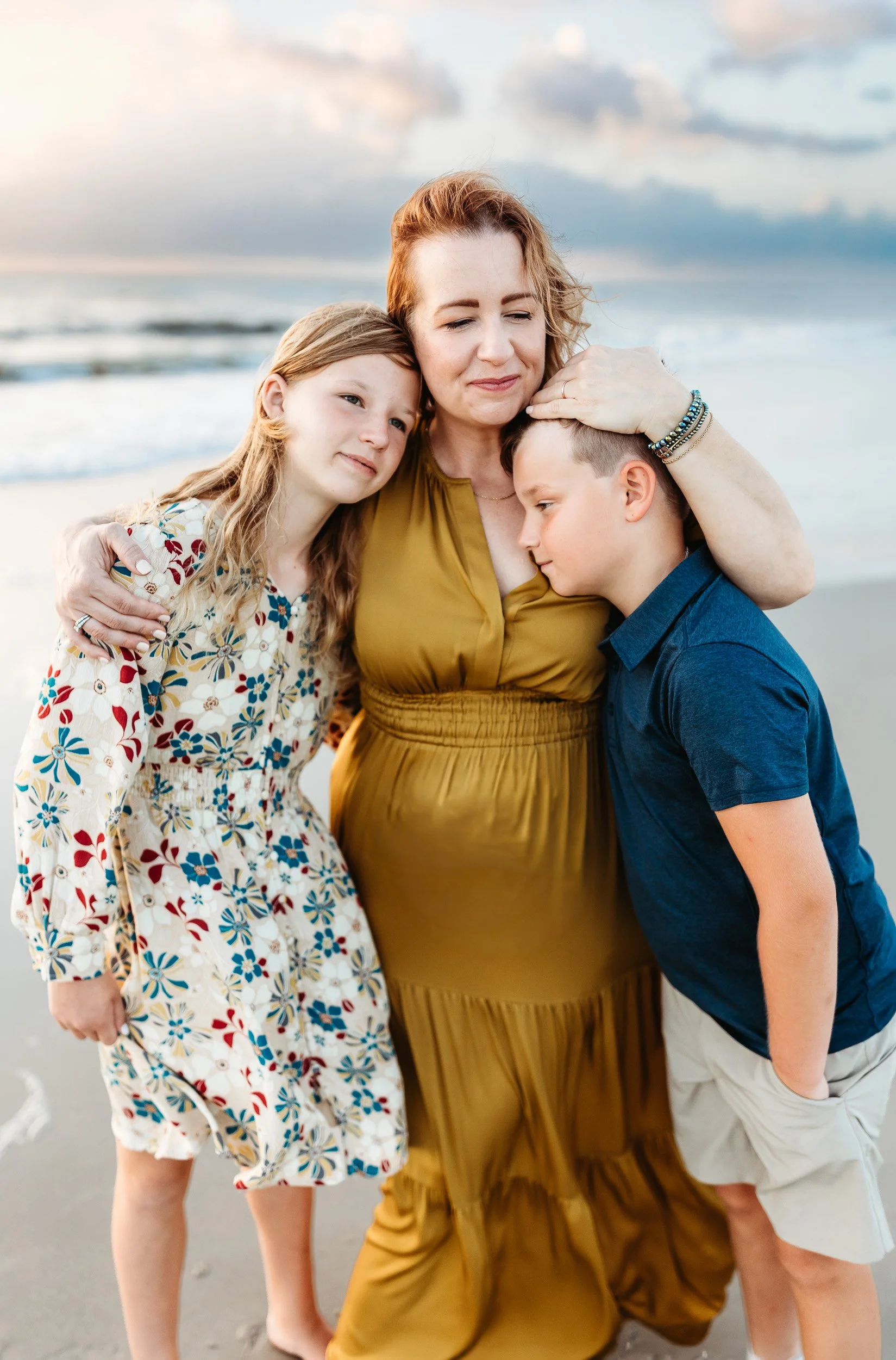 mother embracing her children and smiling and she is on the beach