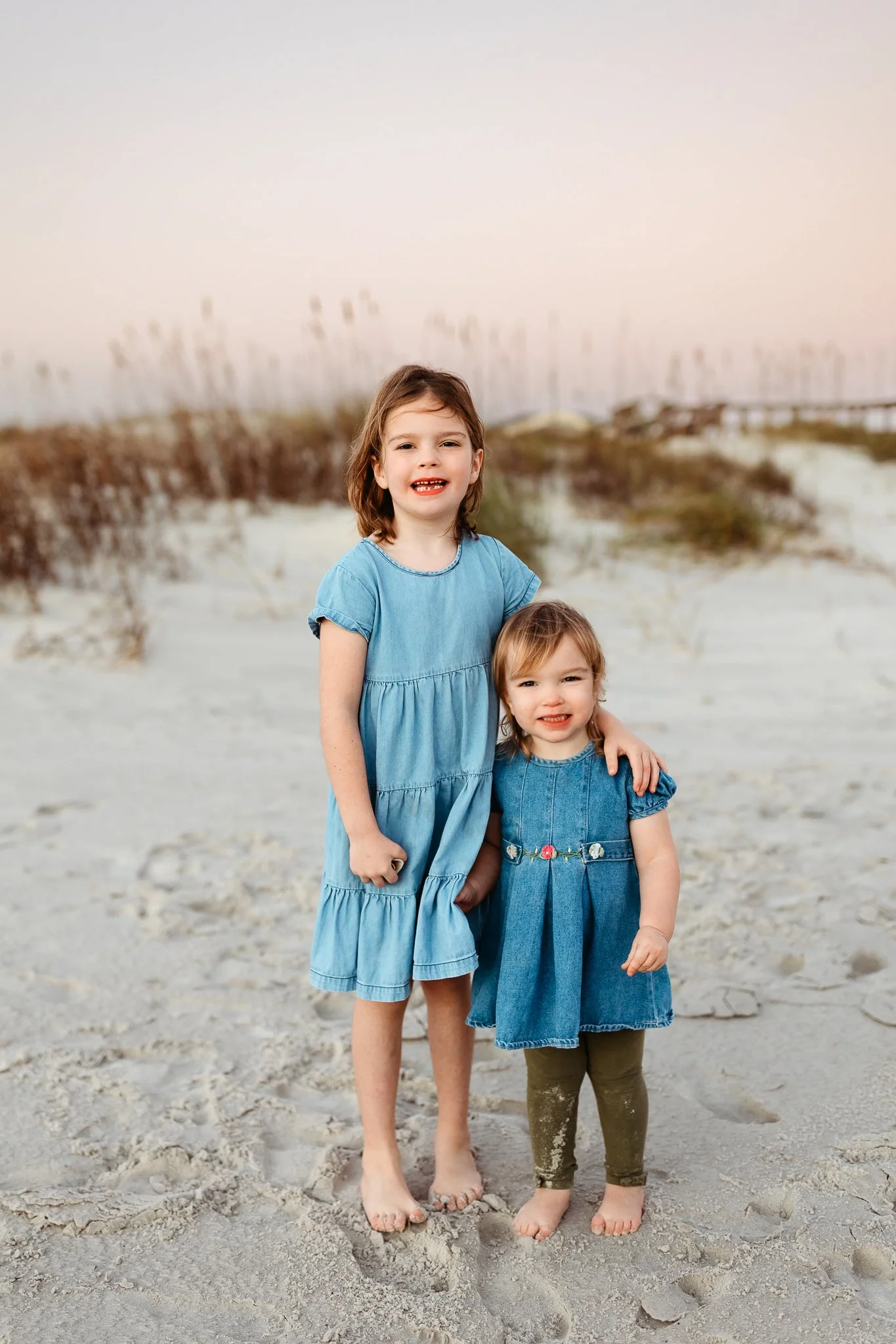 toddler siblings on the beach at sunrise