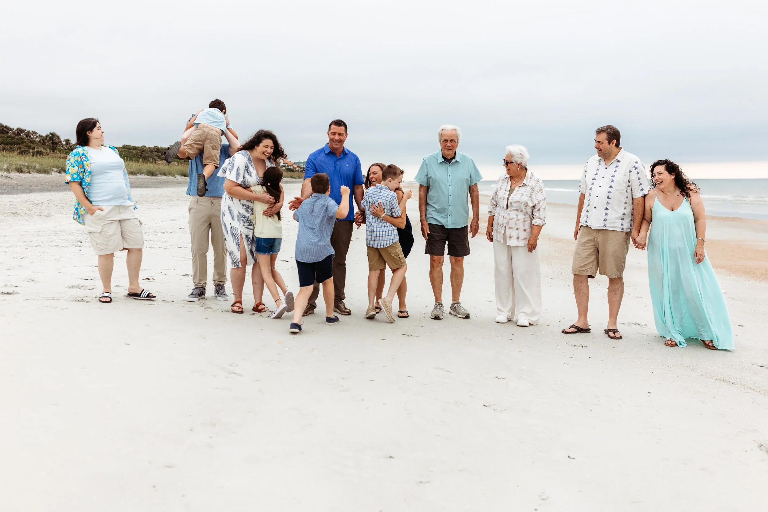 family laughing as children run to them and they lift them up in the air