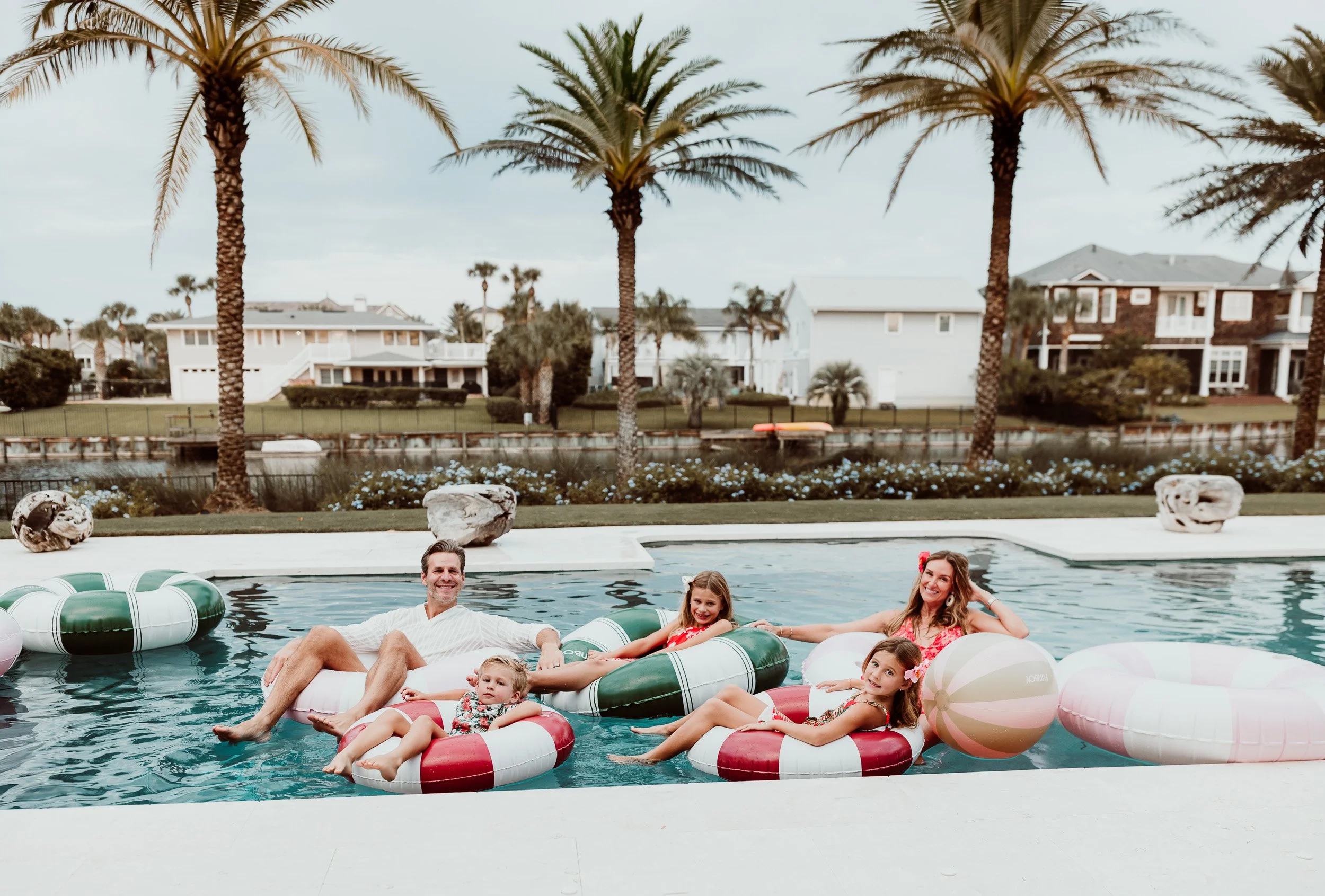 Family enjoying time together in their backyard swimming pool