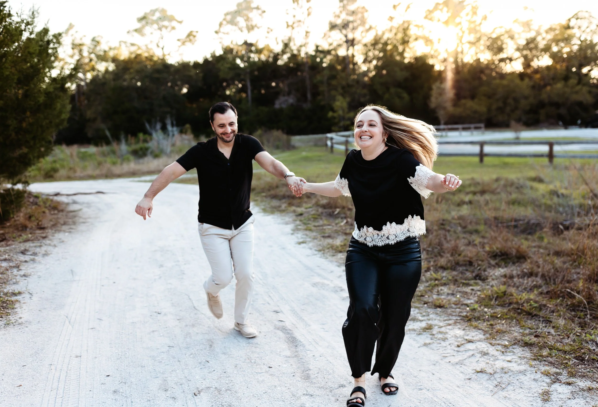 couple running at sunset in nocatee during engagement photo session