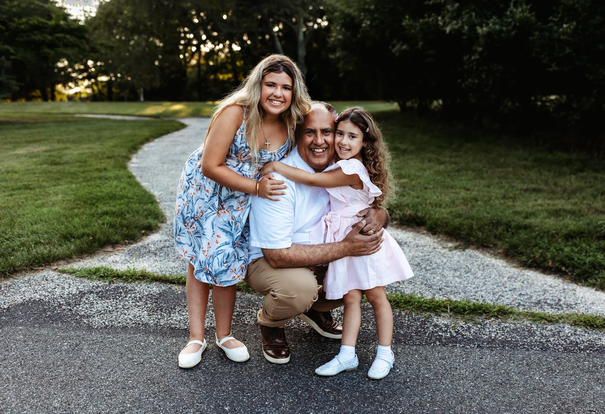 dad embracing his daughters at Walter jones park on a path