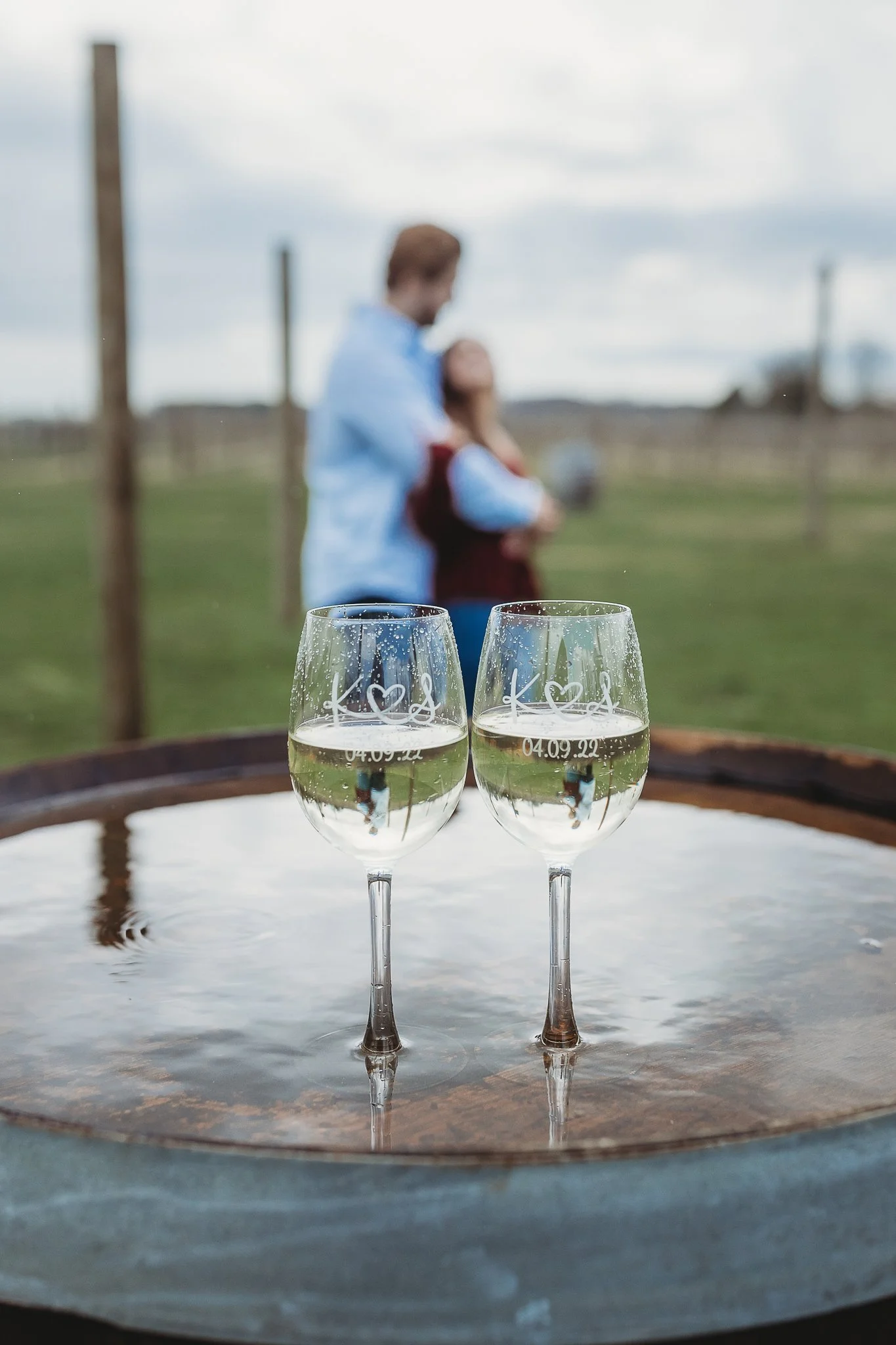 image of a couple who just got engaged and they are reflected  in wine glasses