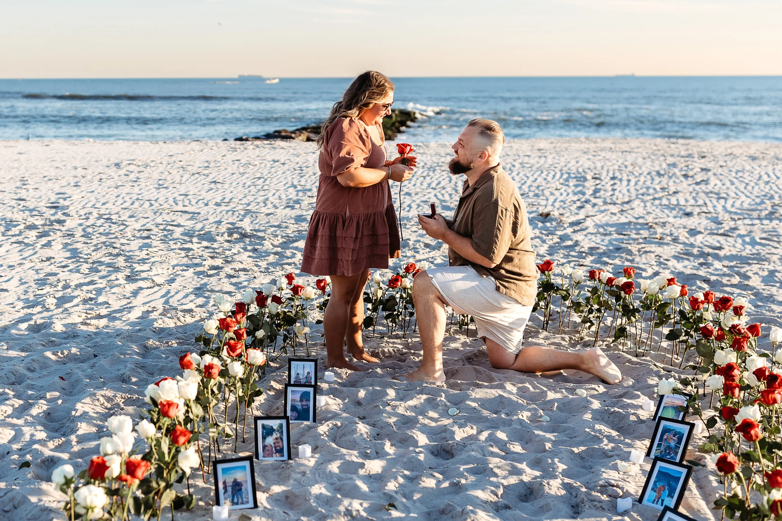 man proposing to a woman on the beach in st augustine in field of flower petals and photos 