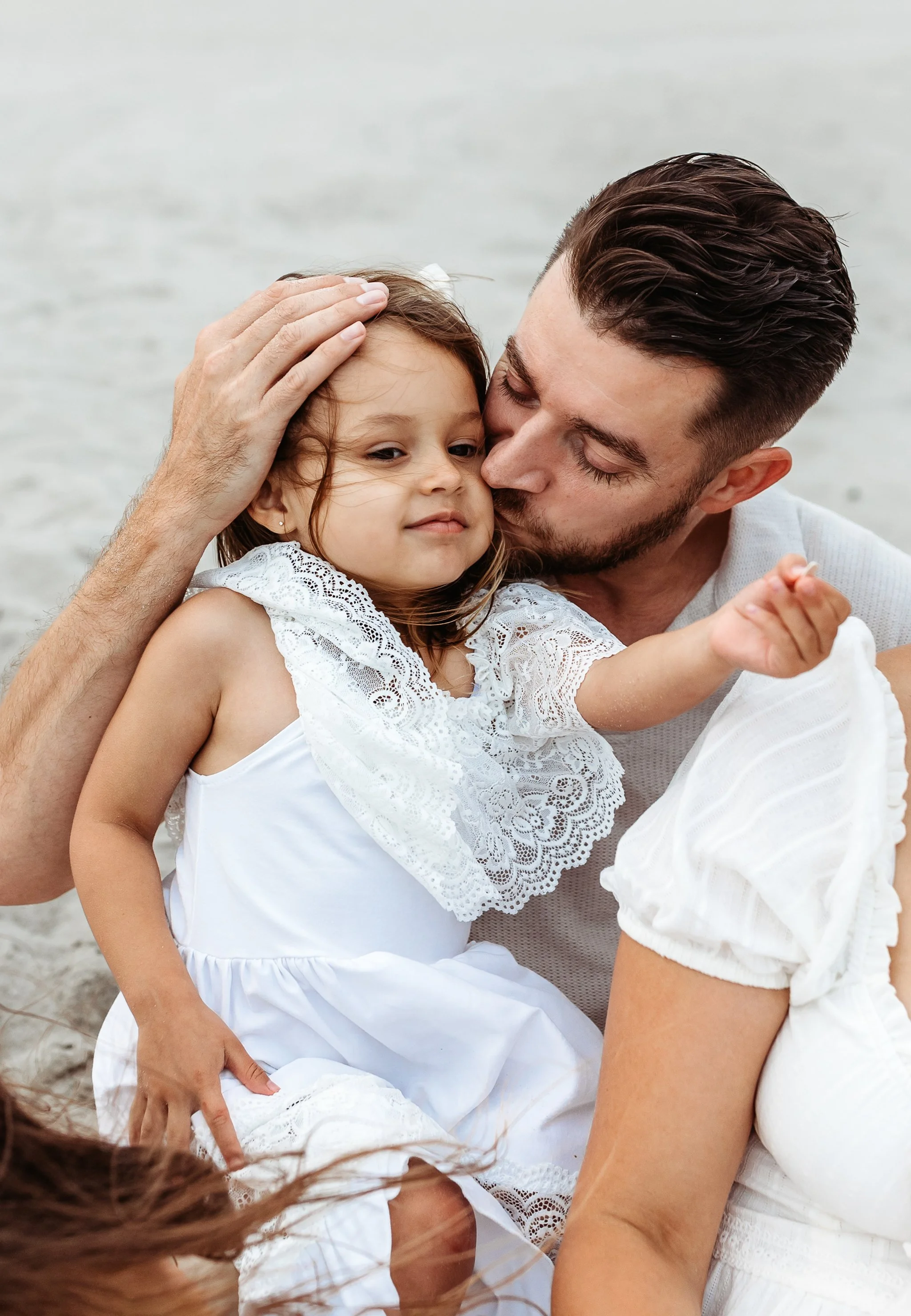 close upon dad kissing toddler girl who is laughing