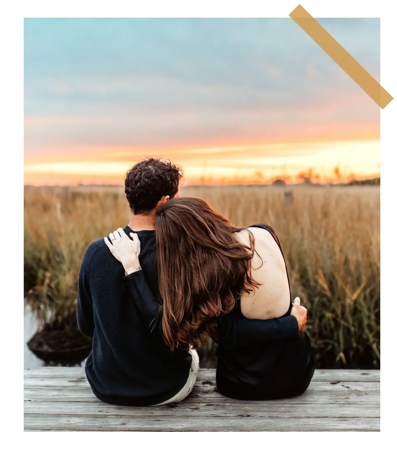 couple seated on a dock at sunset embraced with backs to camera