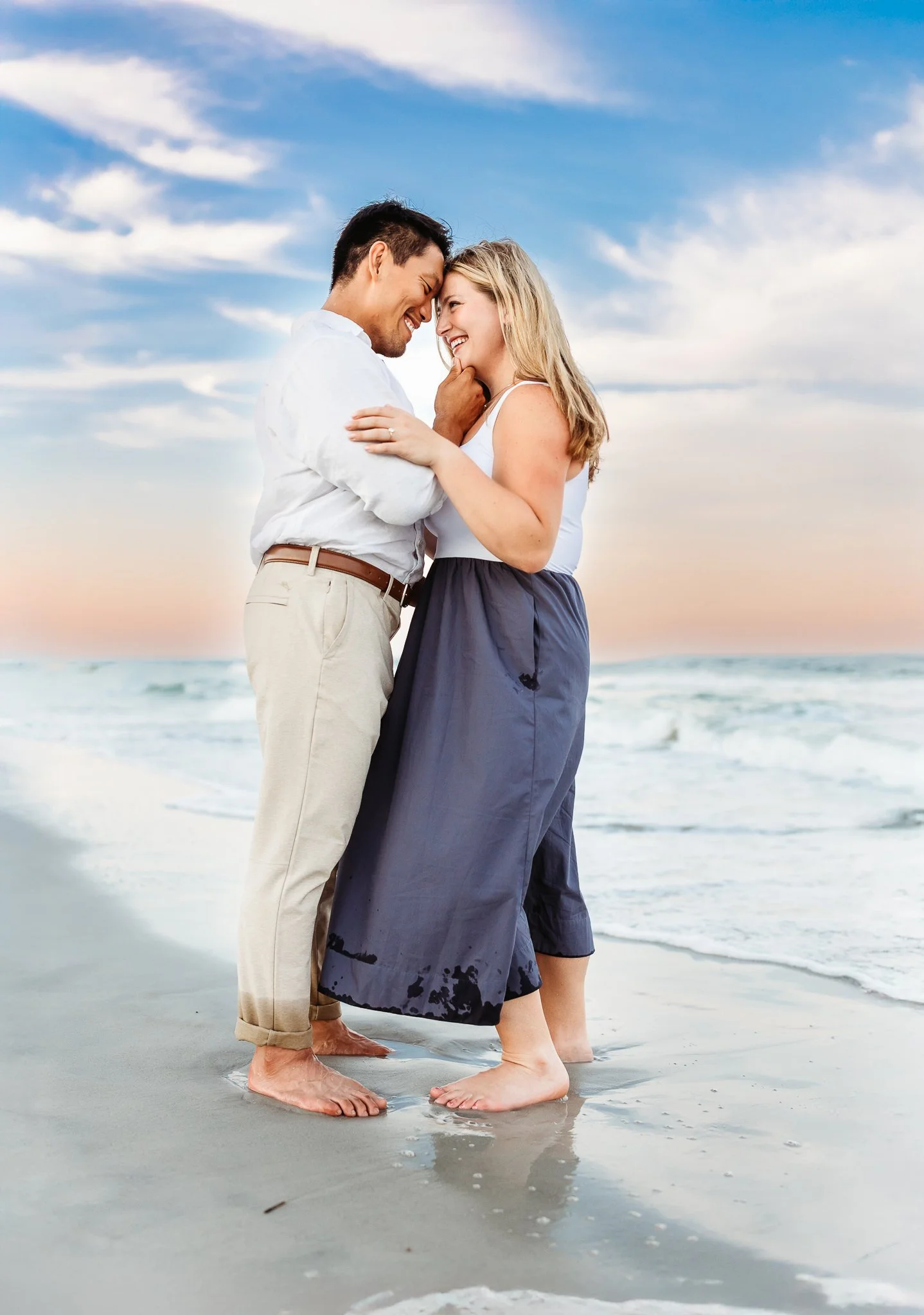 couple on the beach at blue hour and man's hand is under woman's chin and they are forehead to forehand and they are at the beach at the Ponte Vedra inn and club