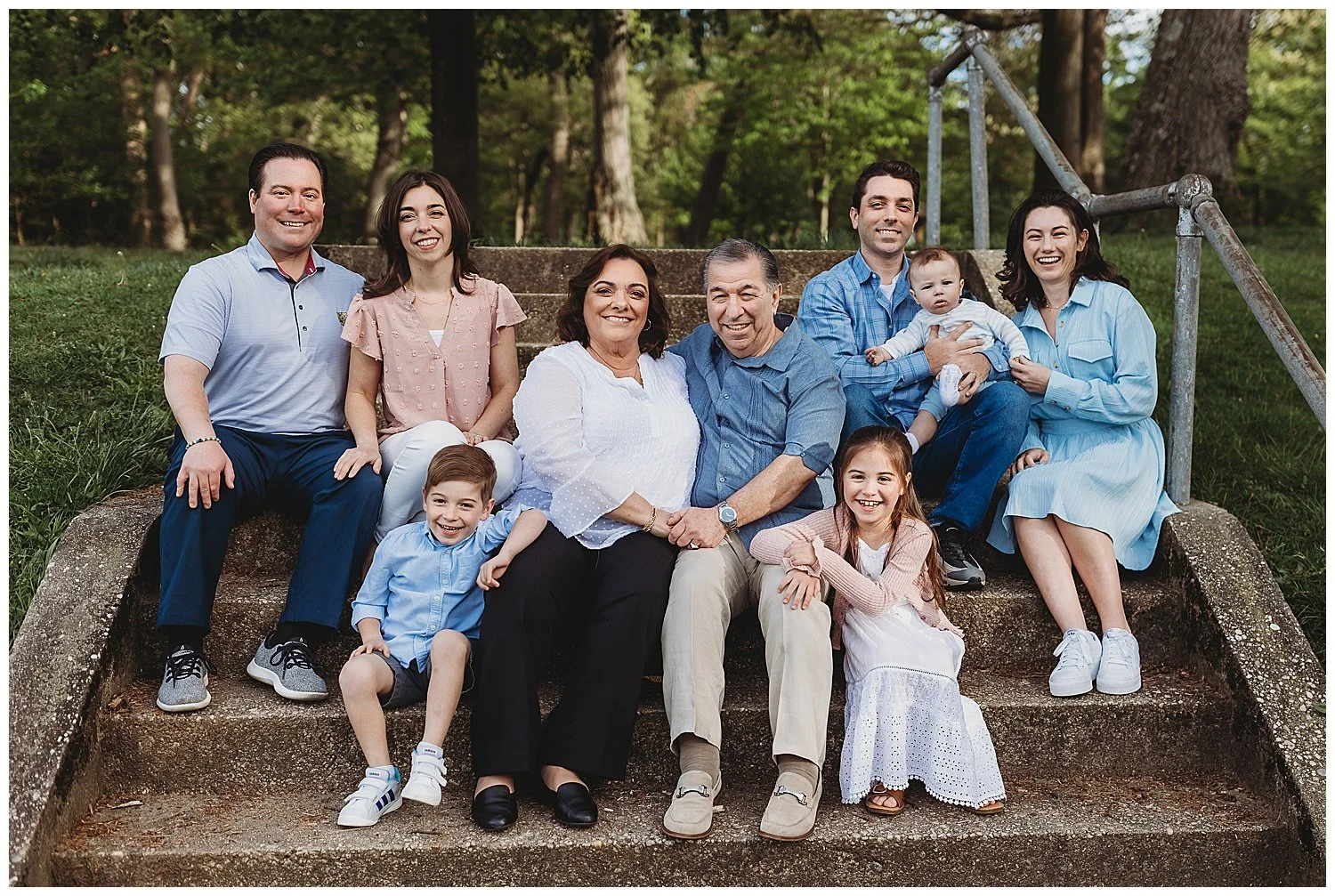 multi generational  family dressed in pink and blue on concrete stairs