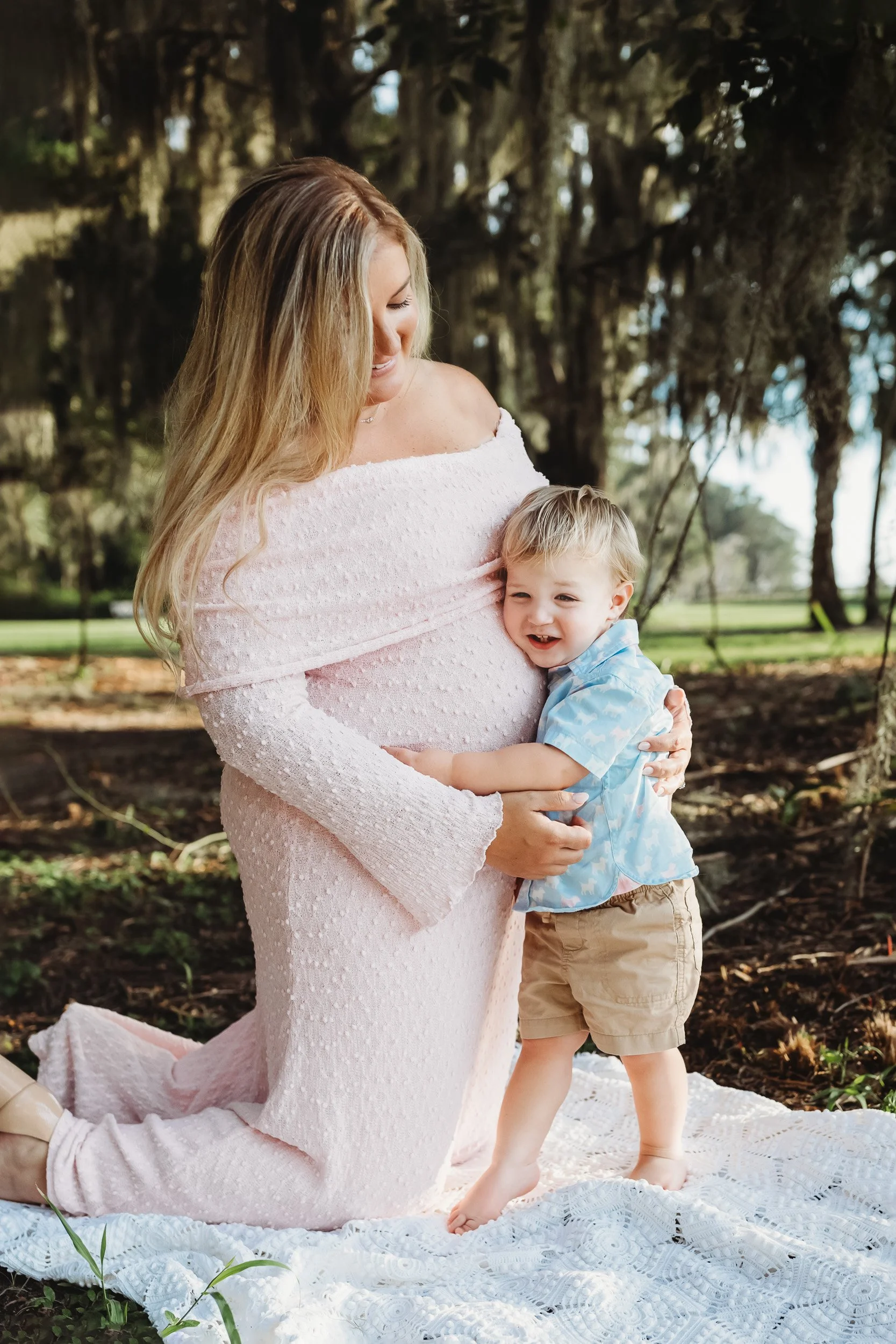 Toddler hugging their pregnant mother during a relaxed family maternity session in Northeast Florida.