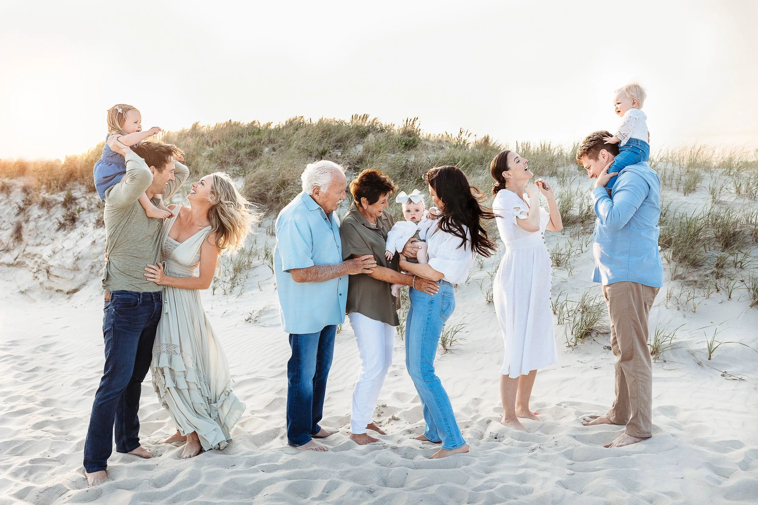 fun family moment at Guana Middle Beach.  each individual family is either hugging someone or laughing.   