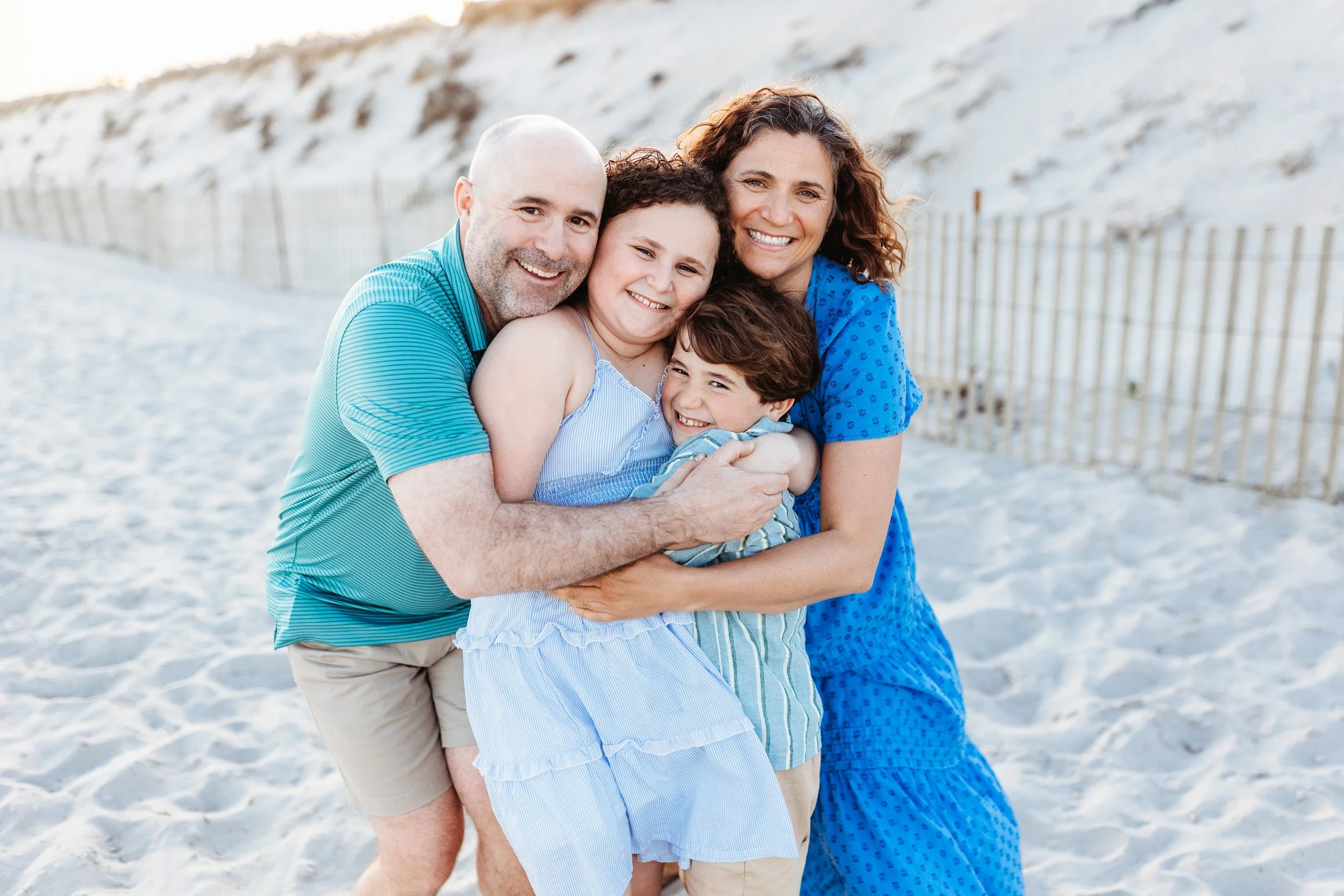 Candid family photo of a family embraced on the beach in St. Augustine Florida