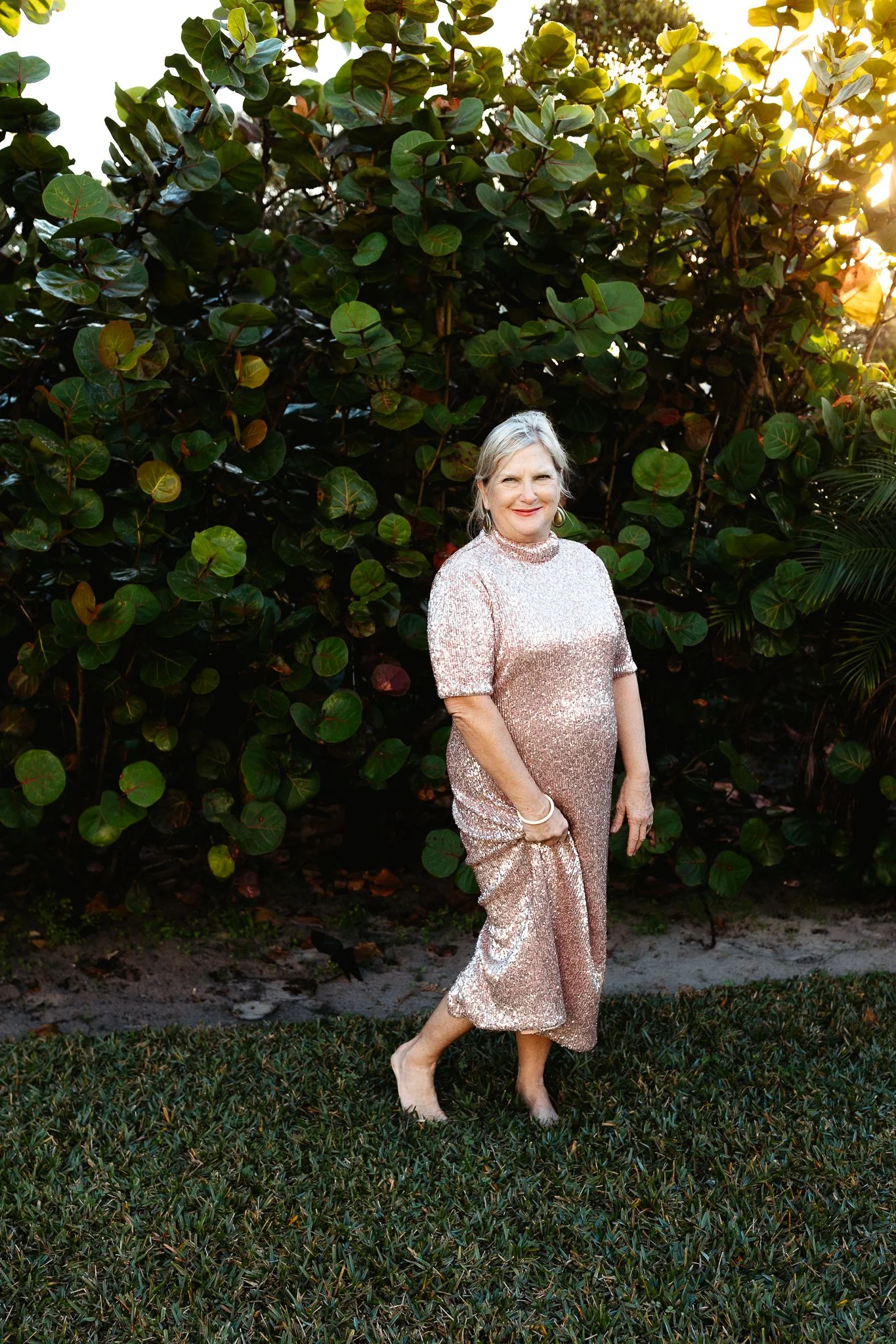 Woman in a gold sequin dress smiling during a milestone 70th birthday portrait session in St. Augustine, Florida.