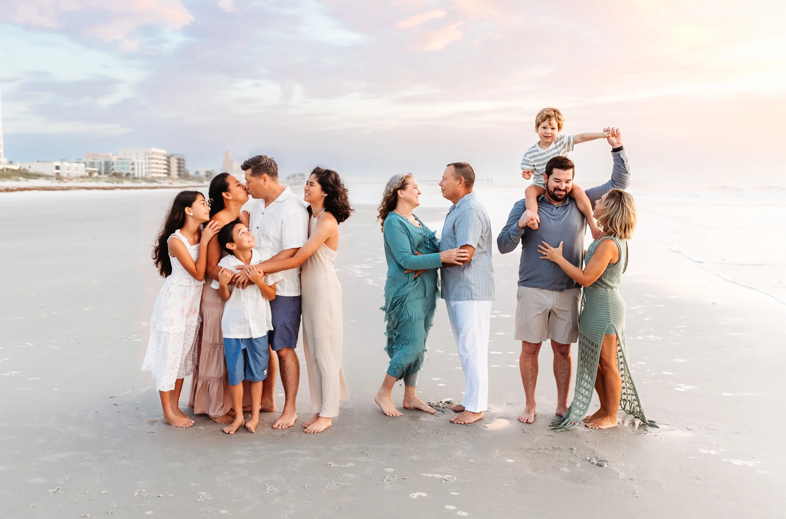 natural and relaxed large group family portrait of a family interacting on Jax beach at sunrise