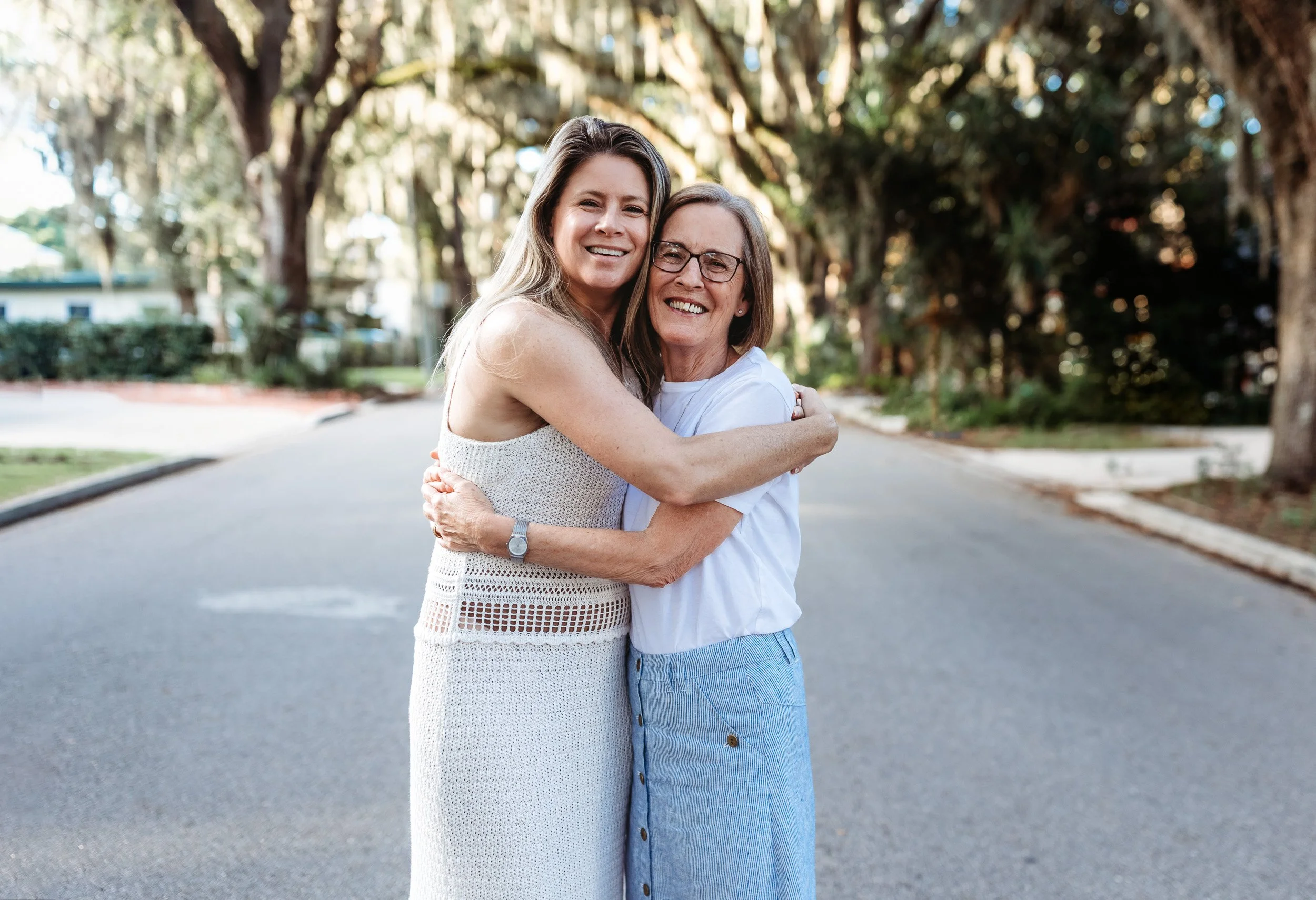adult woman with her mom and they are embraced and laughing during their vacation family photo session in st augustine