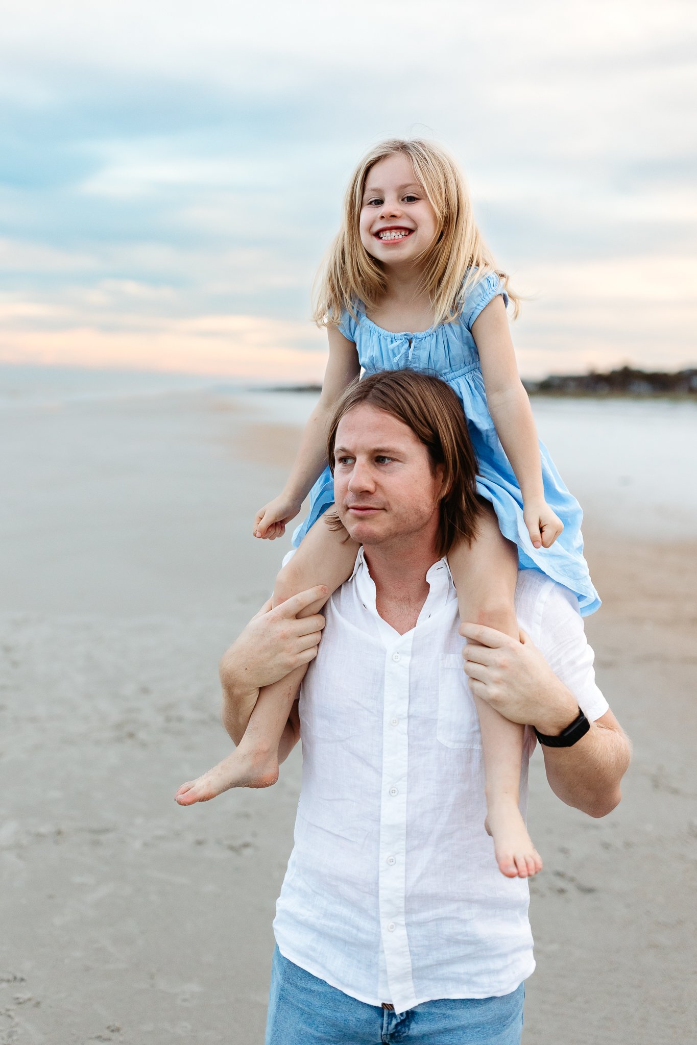 uncle with toddler niece on shoulders and she is laughing