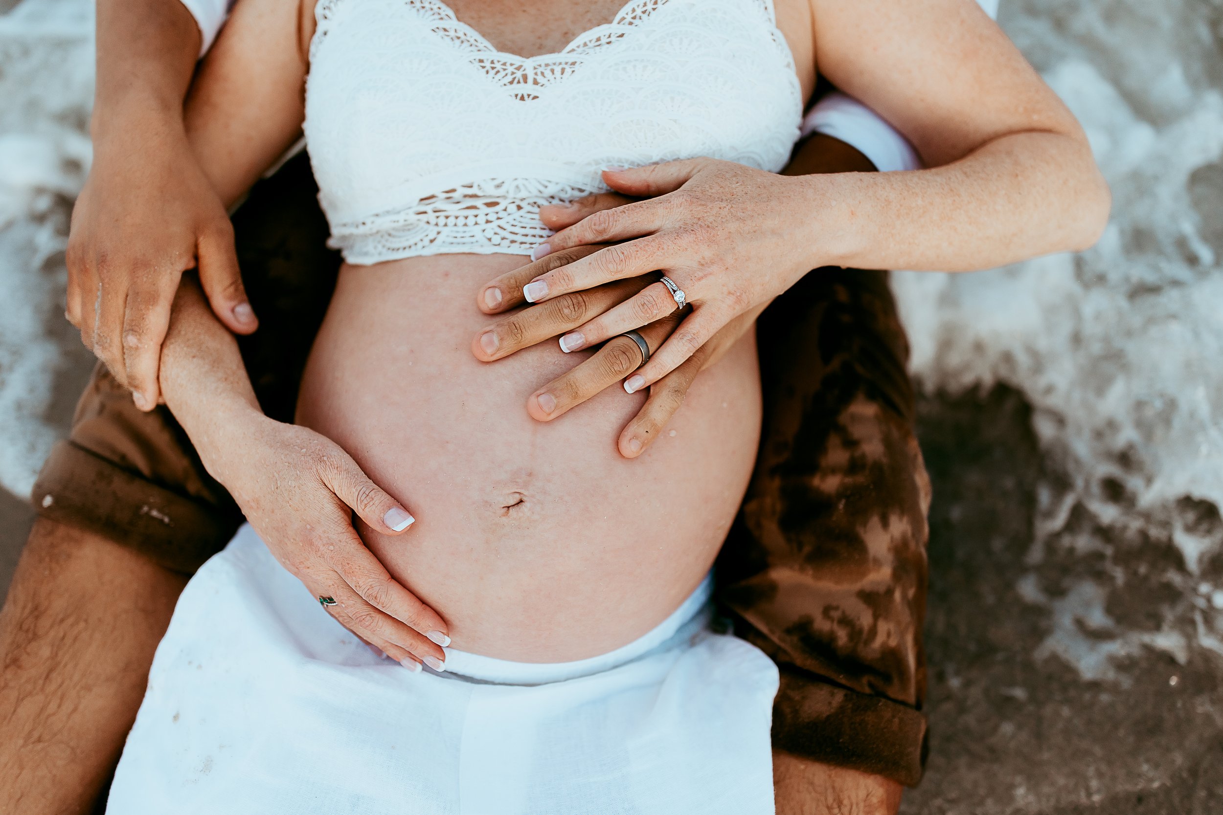 close up of pregnant woman's belly an man's hands on the belly 