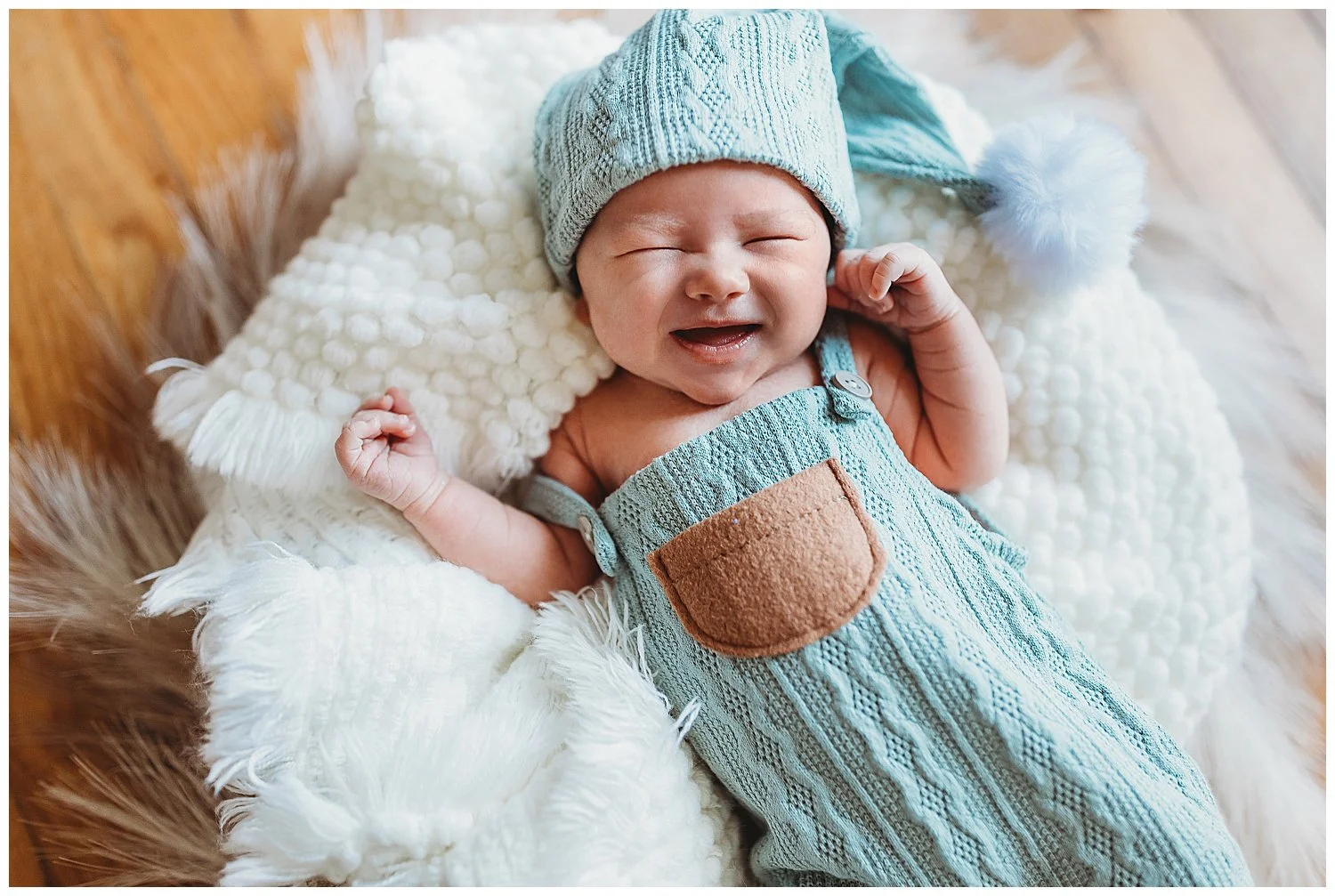 portrait of baby boy in knit jumper smiling with cap on
