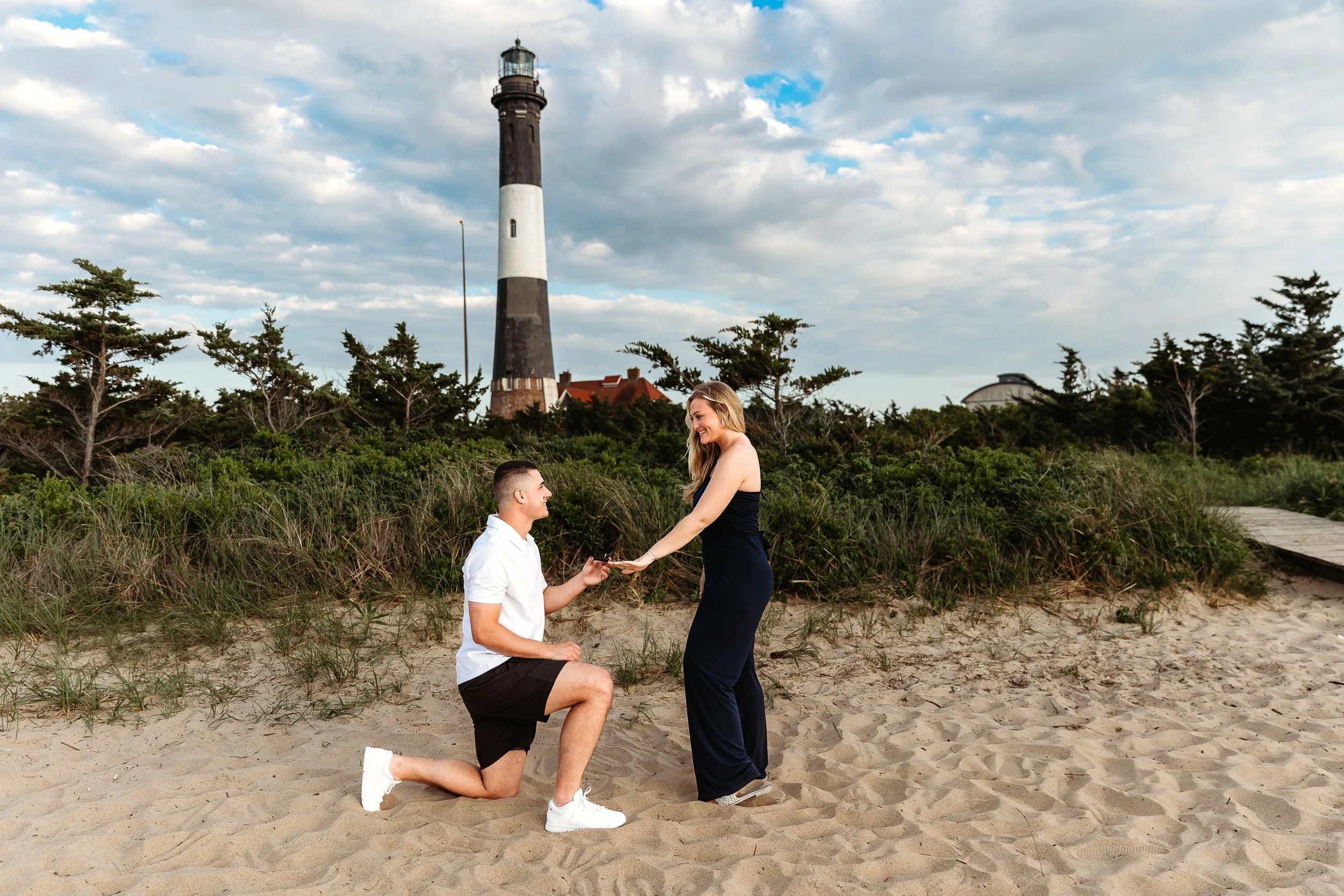 man and woman in front of a lighthouse in st augustine getting engaged