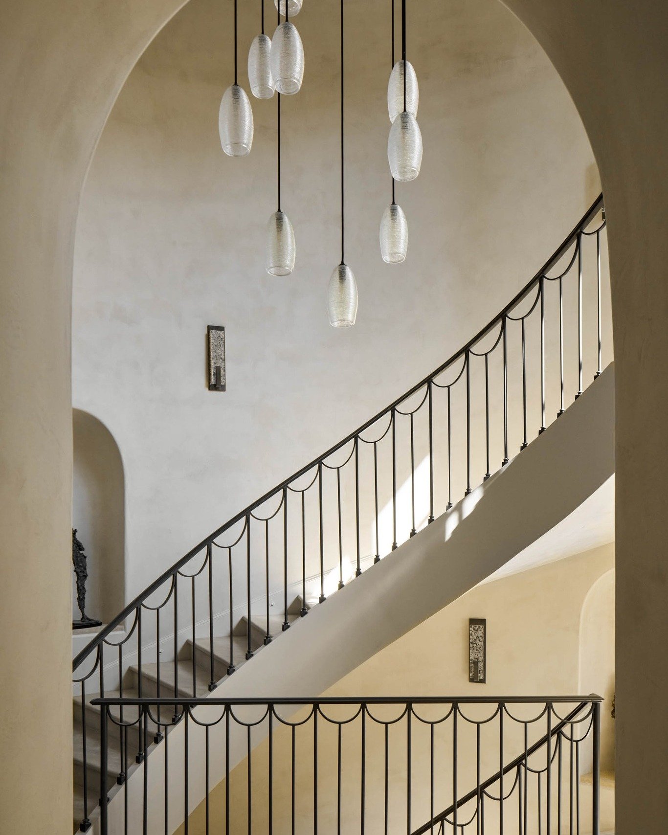 This stunning hand cut Moroccan limestone staircase with custom iron railing complement the natural beauty of the LimeStrong limestone washed walls. 

The dramatic multi-pendant chandelier is the perfect finishing touch to this grand stairway.