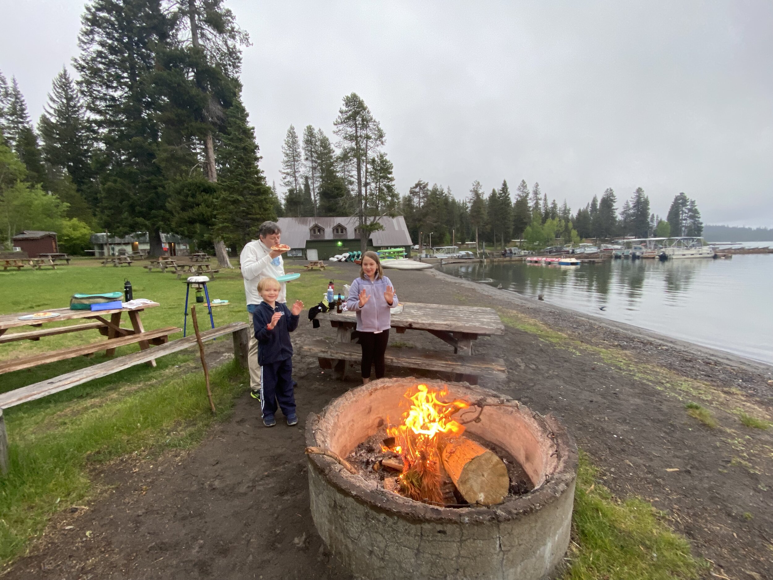 Picnicking, warming up, and drying off from the drizzle at our dinner campfire on the shore of Diamond Lake.  Photo by Karen Boudreaux, June 13, 2021