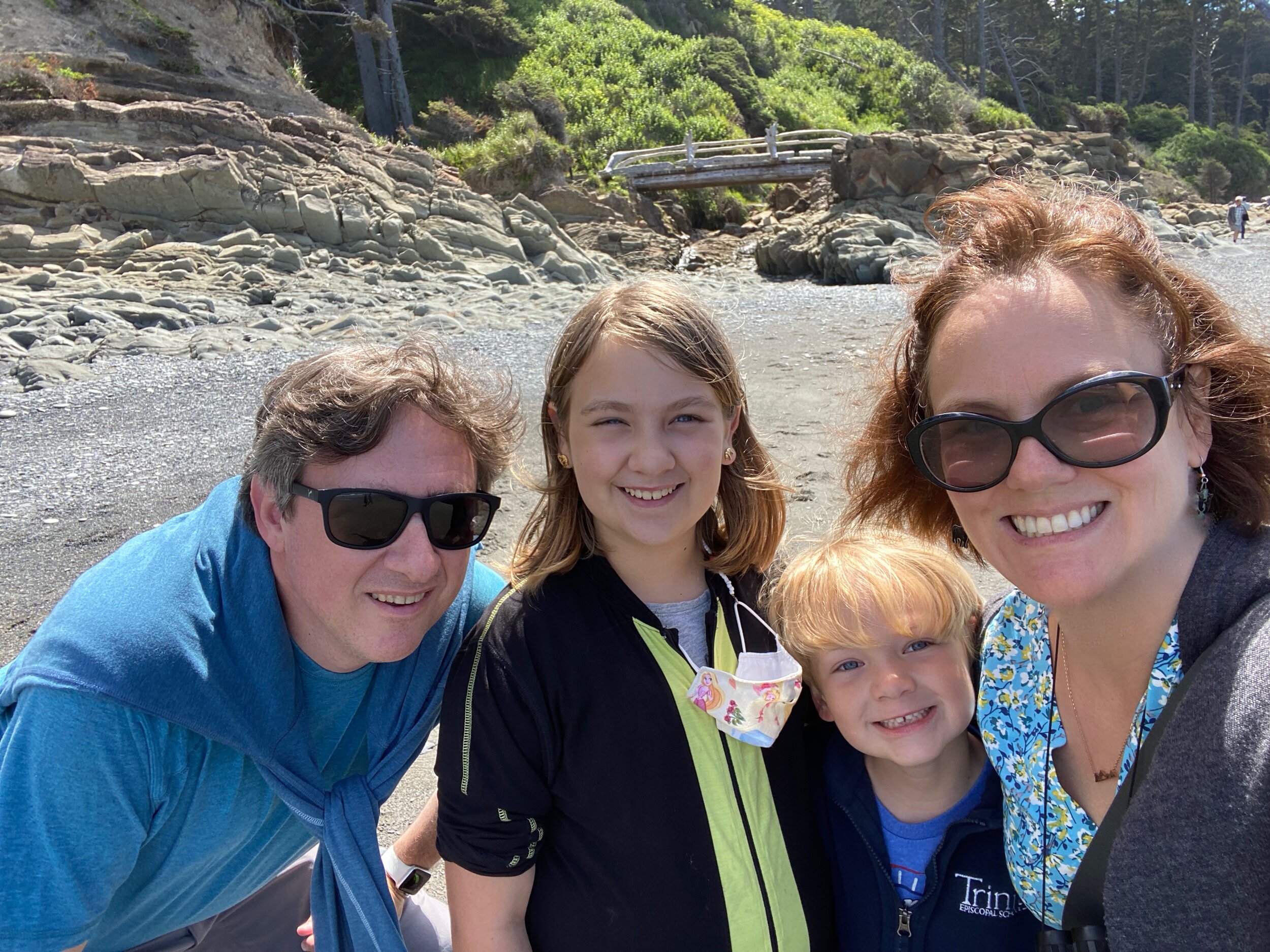 Our family (bridge and rock formation down to the beach behind us) after a fun and successful adventure tide-pooling at Beach 4