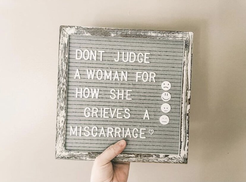 sign that reads &quot;don't judge a woman for how she grieves a miscarriage&quot;