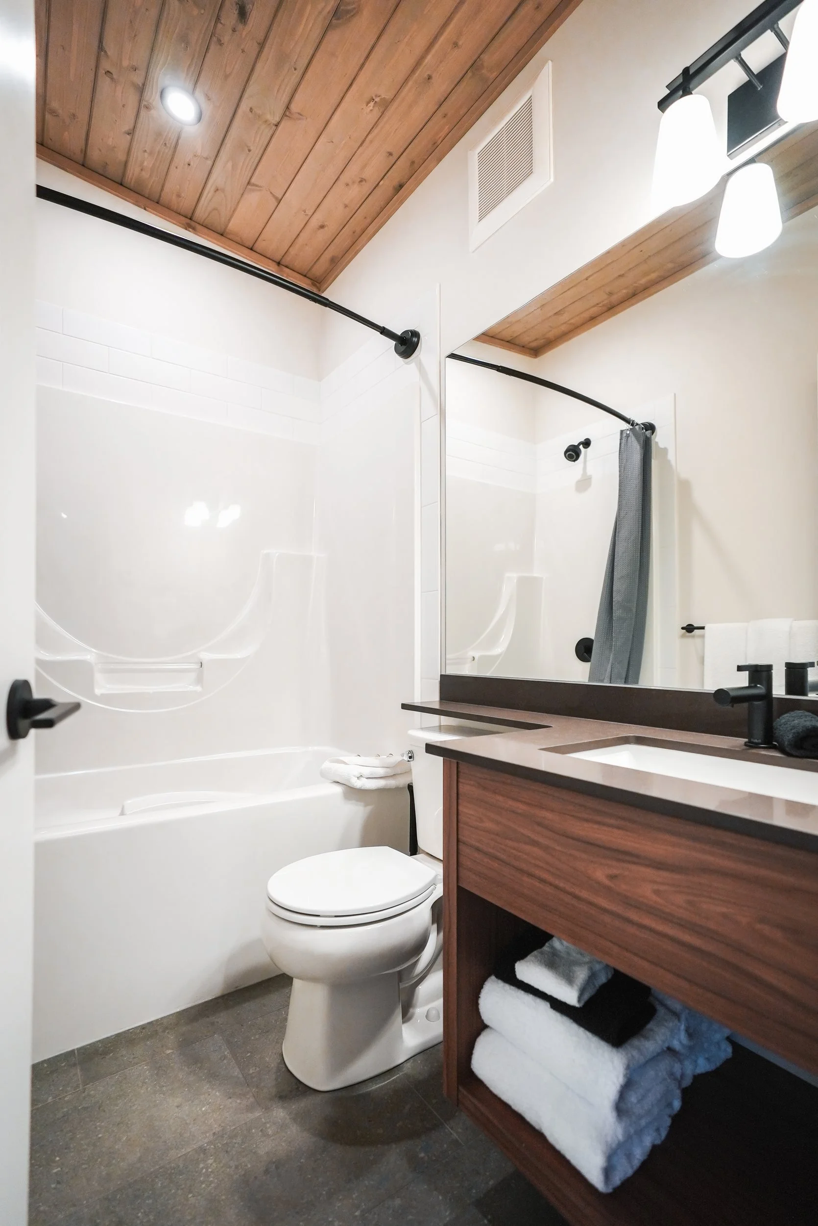 Selkirk bathroom with a tub and shower and a wood vanity