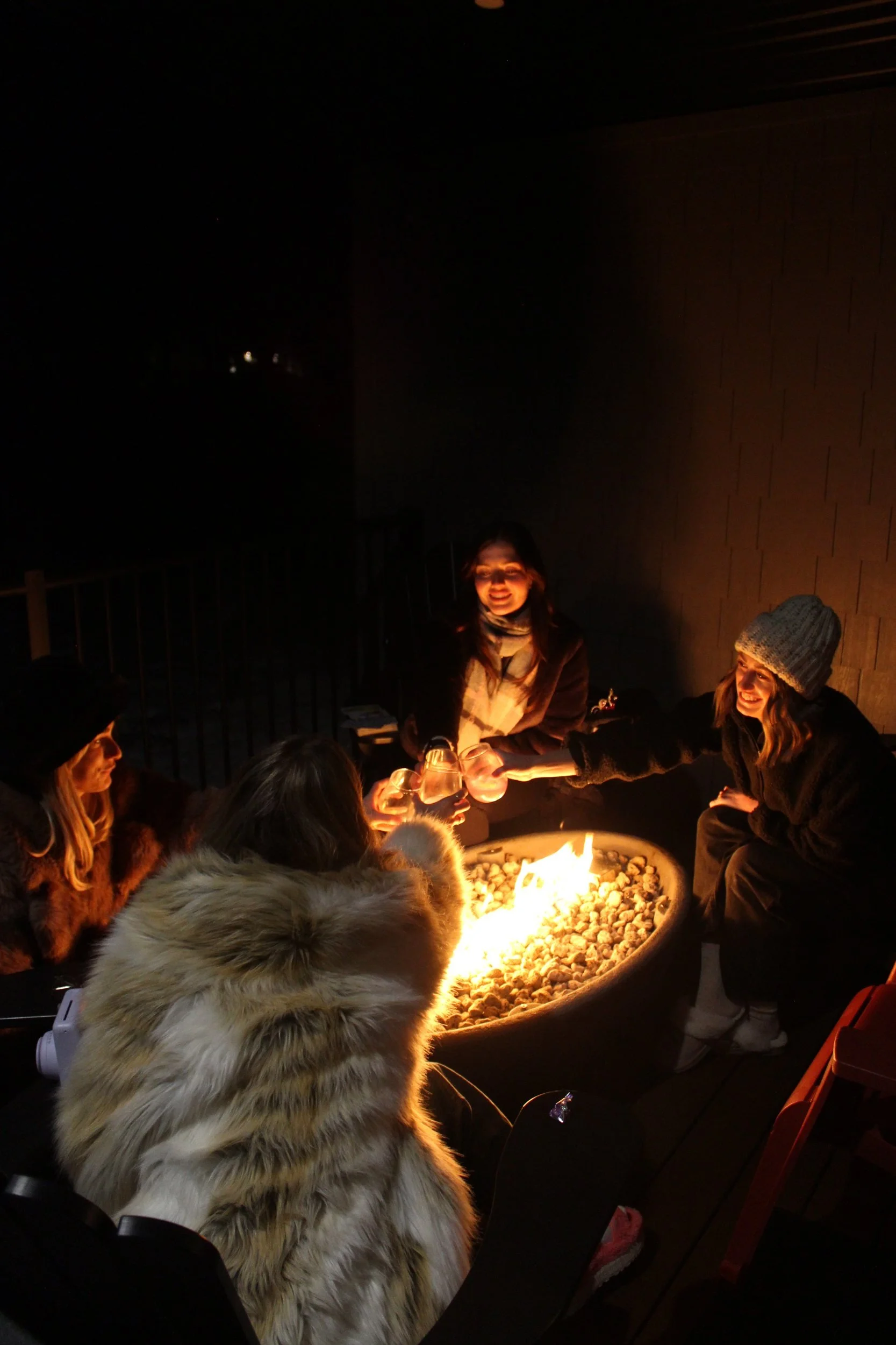 Friends wrapped in blankets around the fire pit in the evening at the Shuswap