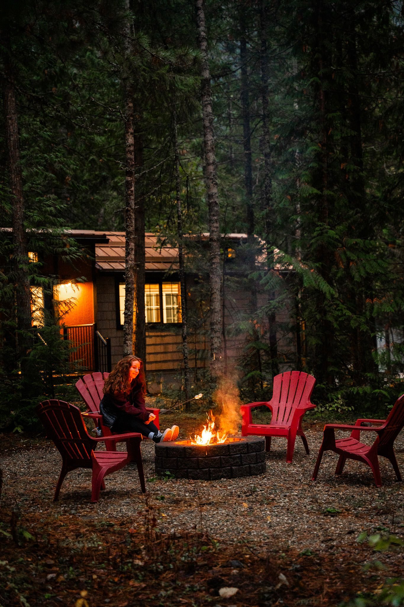 Guest by the fire pit at night, with the Elkhorn lit up behind