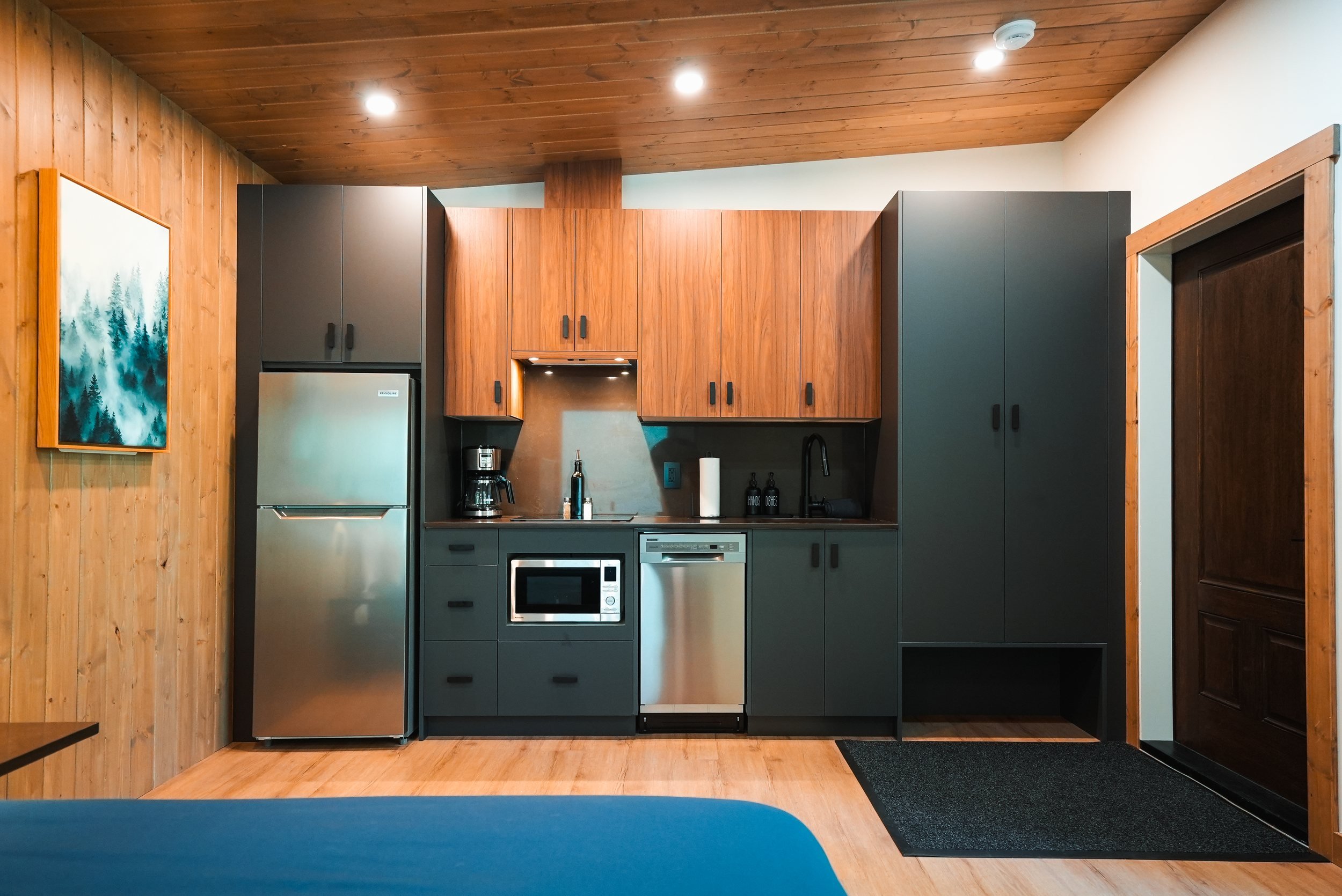 Nest kitchen with wood and charcoal cabinets and stainless steel appliances