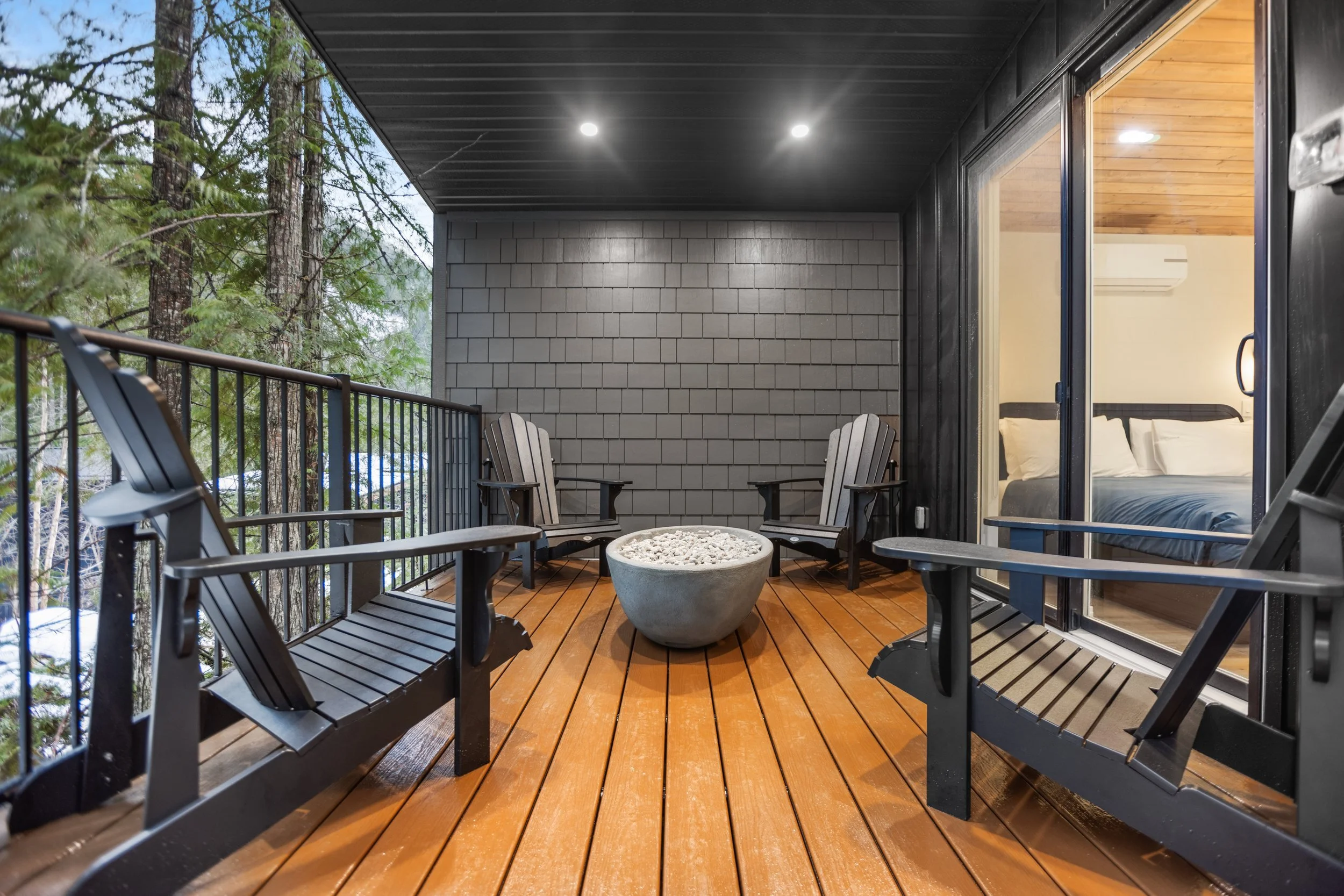 Adirondack chairs around the gas fire pit on the covered deck of the Shuswap